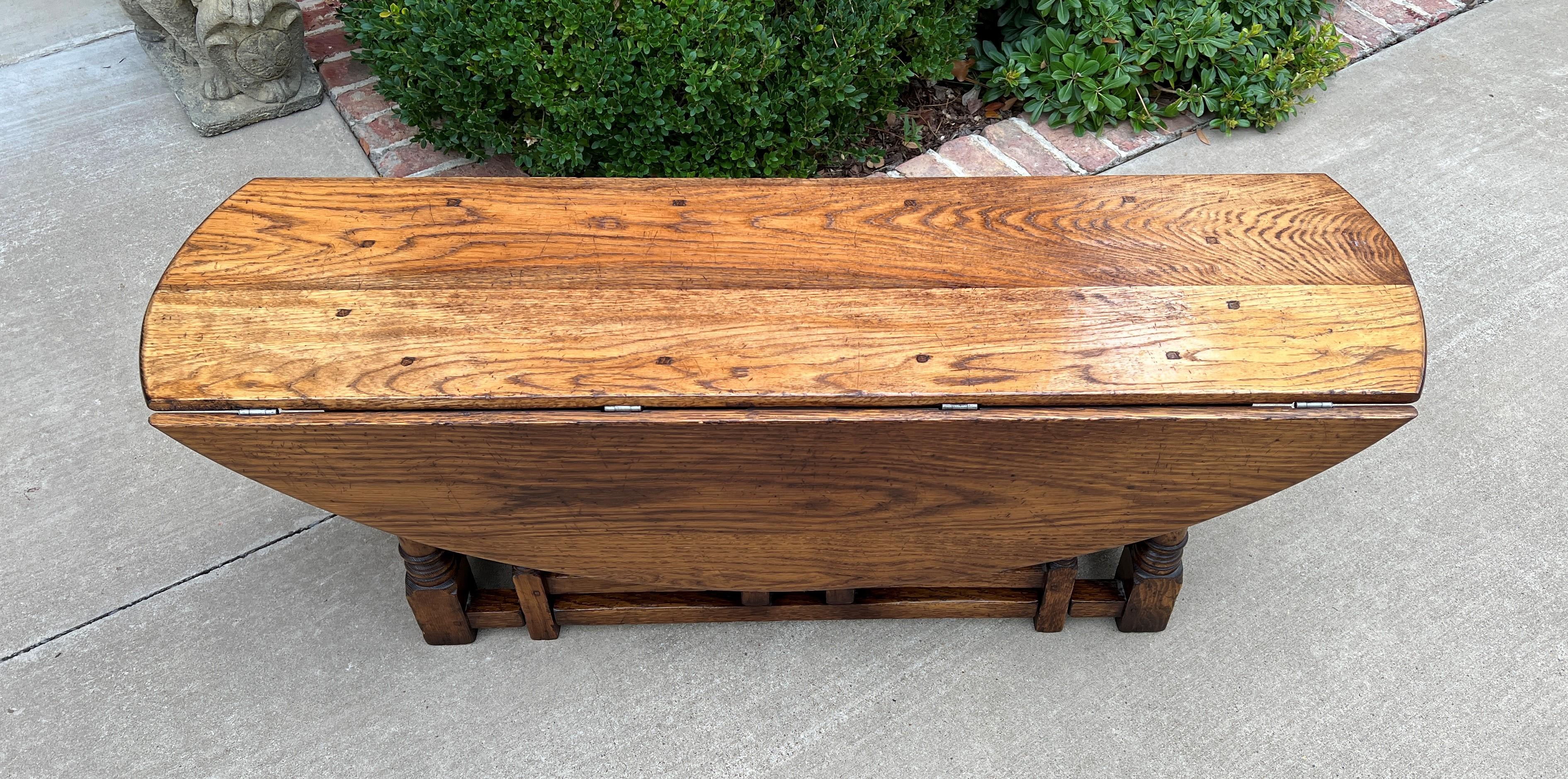 Rare antique English oak gate leg drop leaf coffee table or bench~~c.1900 or earlier.

Versatile piece with so many functions~~use as a traditional coffee table or could be used as an entry or hall bench, under a stairwell, or window seat in any