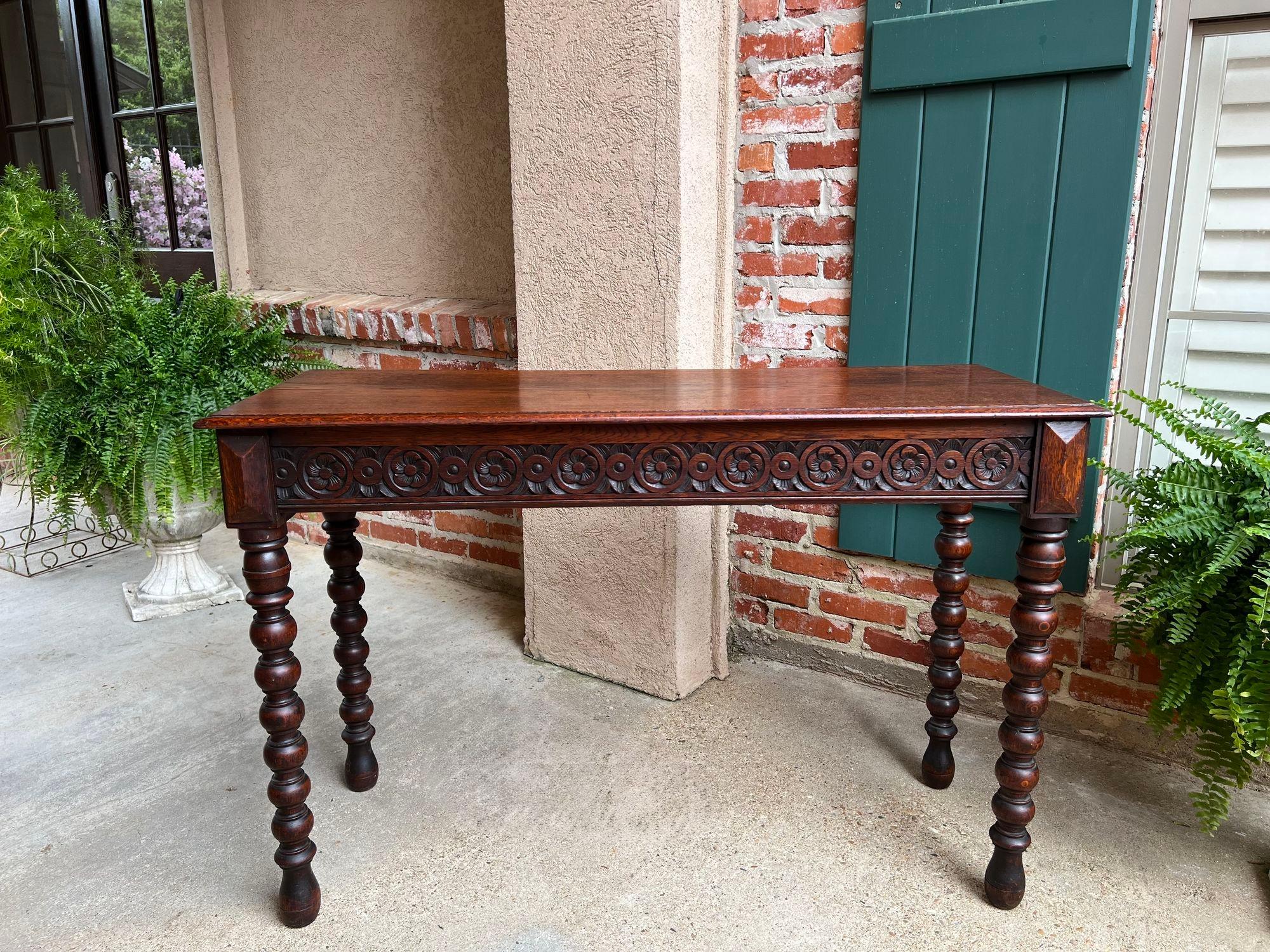 Antique English Console Sofa Table Carved Oak Tudor Bobbin Leg c1890.

Direct from England, a beautiful antique sofa or console table, in a long and slender size, perfect for placement throughout your home!
The table features a wide, hand carved