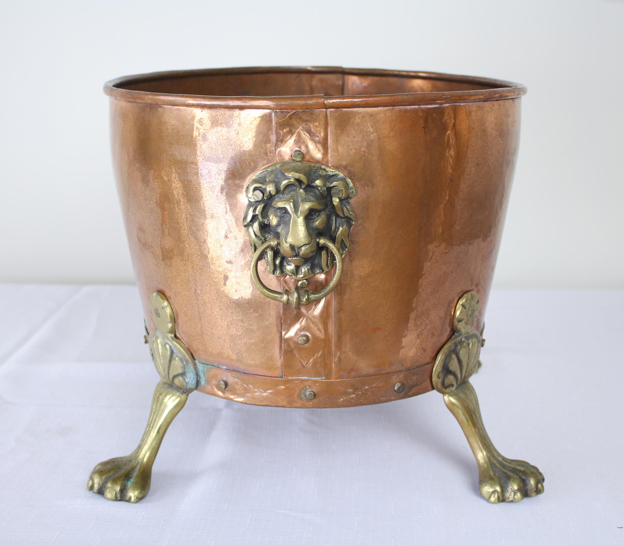 A stylish copper log bin with feline brass accents! Some wear and Verdigris on the inside, to be expected in a piece of this age.