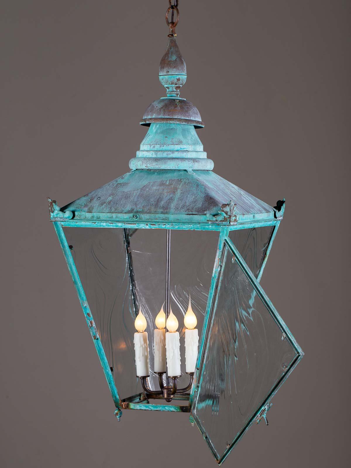 This handsome antique English copper Verdigris lantern circa 1890 has been rewired for American electricity and fitted with a four light interior fixture. The square shape of the lantern with its tapered sides and conical top reflects an age when