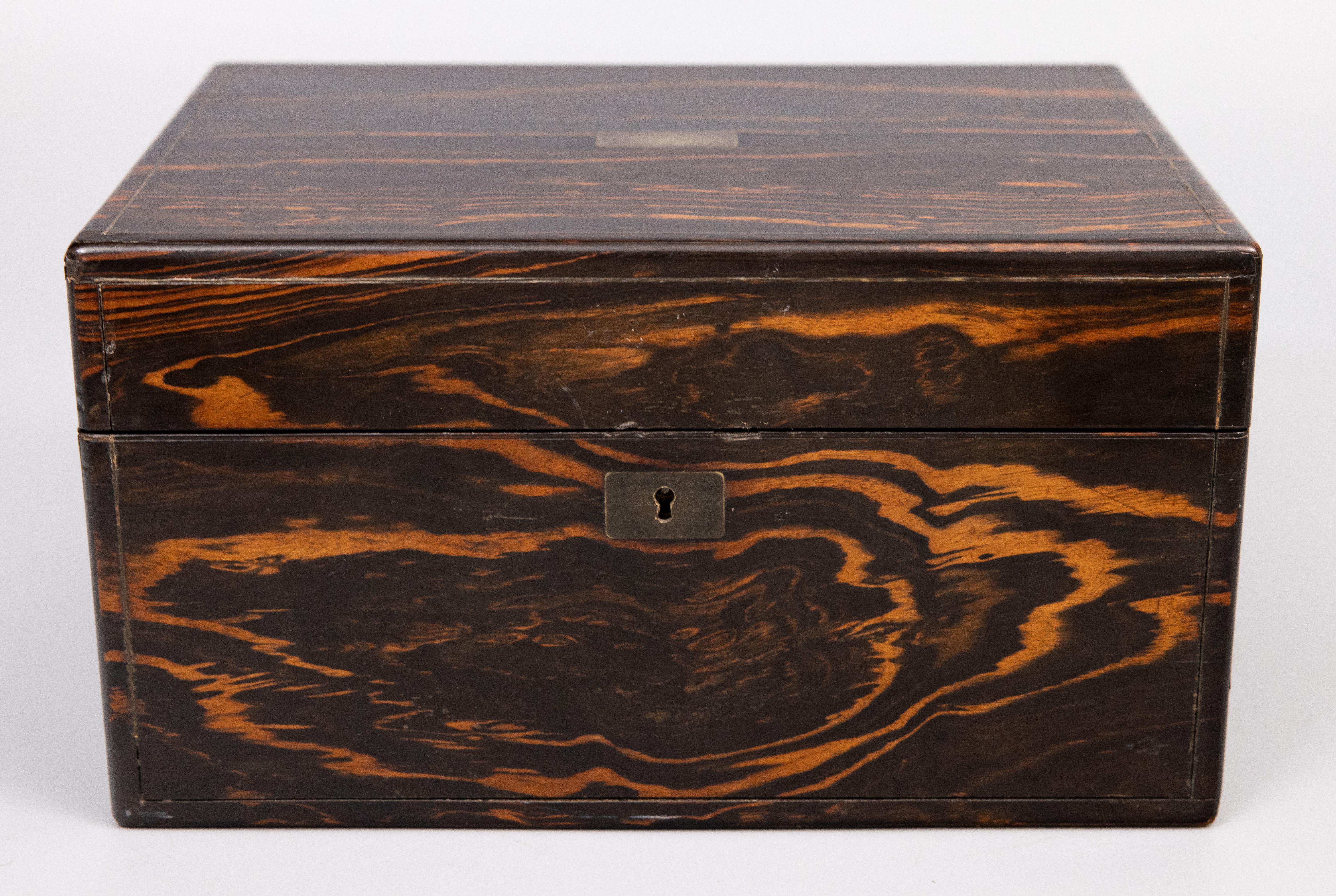 Magnífico tocador inglés antiguo del siglo XIX, de madera de coromandel y palisandro, hacia 1870. Esta fina caja contiene el contenido original, que incluye tarros de cristal tallado con tapa plateada, herramientas de costura, bandeja interior