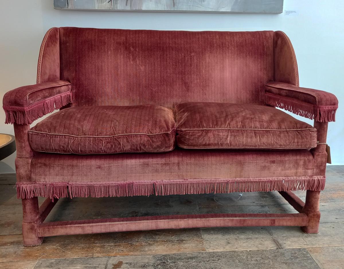 Antique English Country House Wing Back two-seater sofa, circa 1900.
Sofa in burgundy velvet with decorative border and hanging tassel elements. Feather cushion padding. In good used condition, with a few signs of age-related use (see pictures).