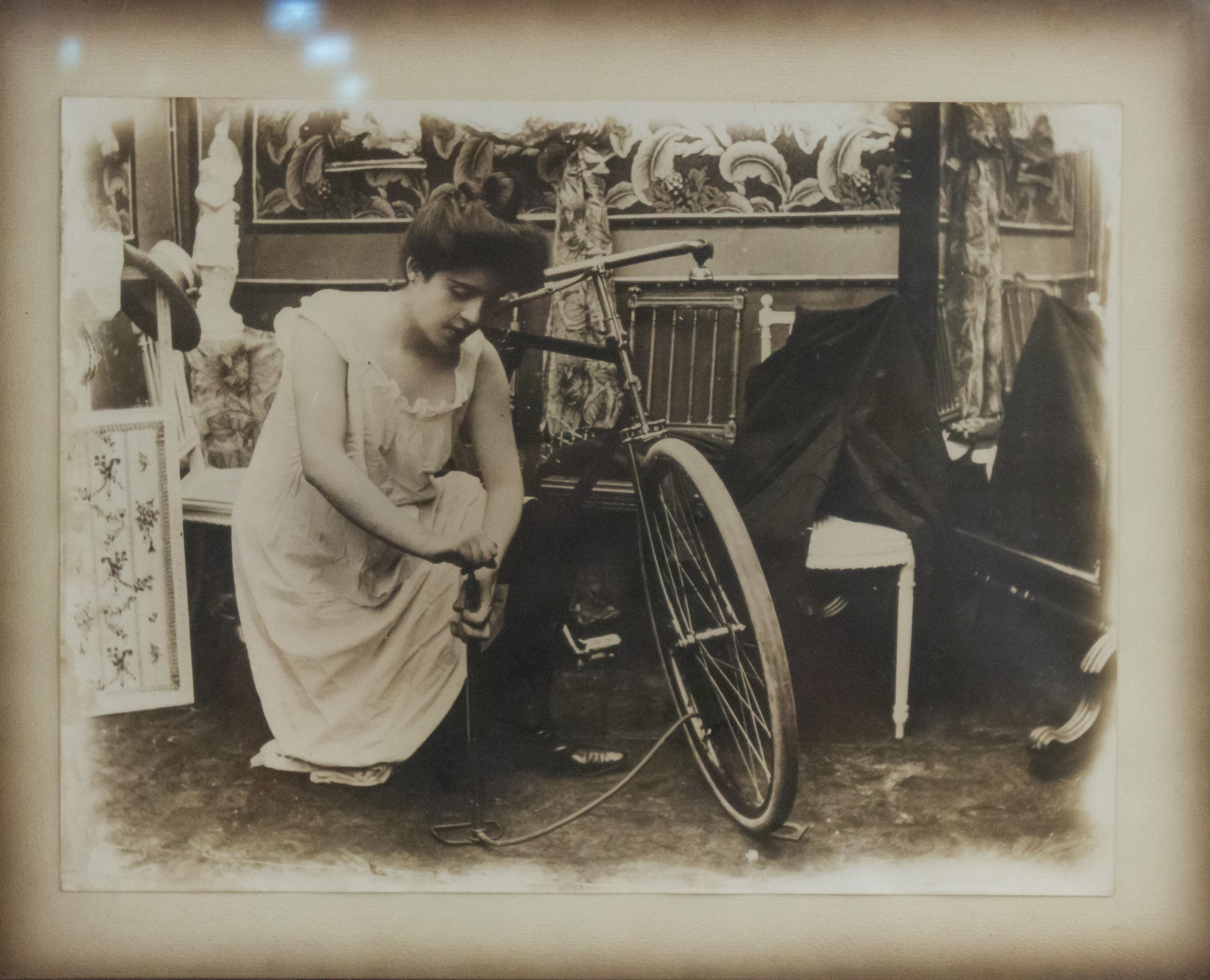 Fotografia incorniciata in noce di una scena del XIX secolo di una signora inginocchiata accanto a una bicicletta (Pezzo complementare: 052554B-E)