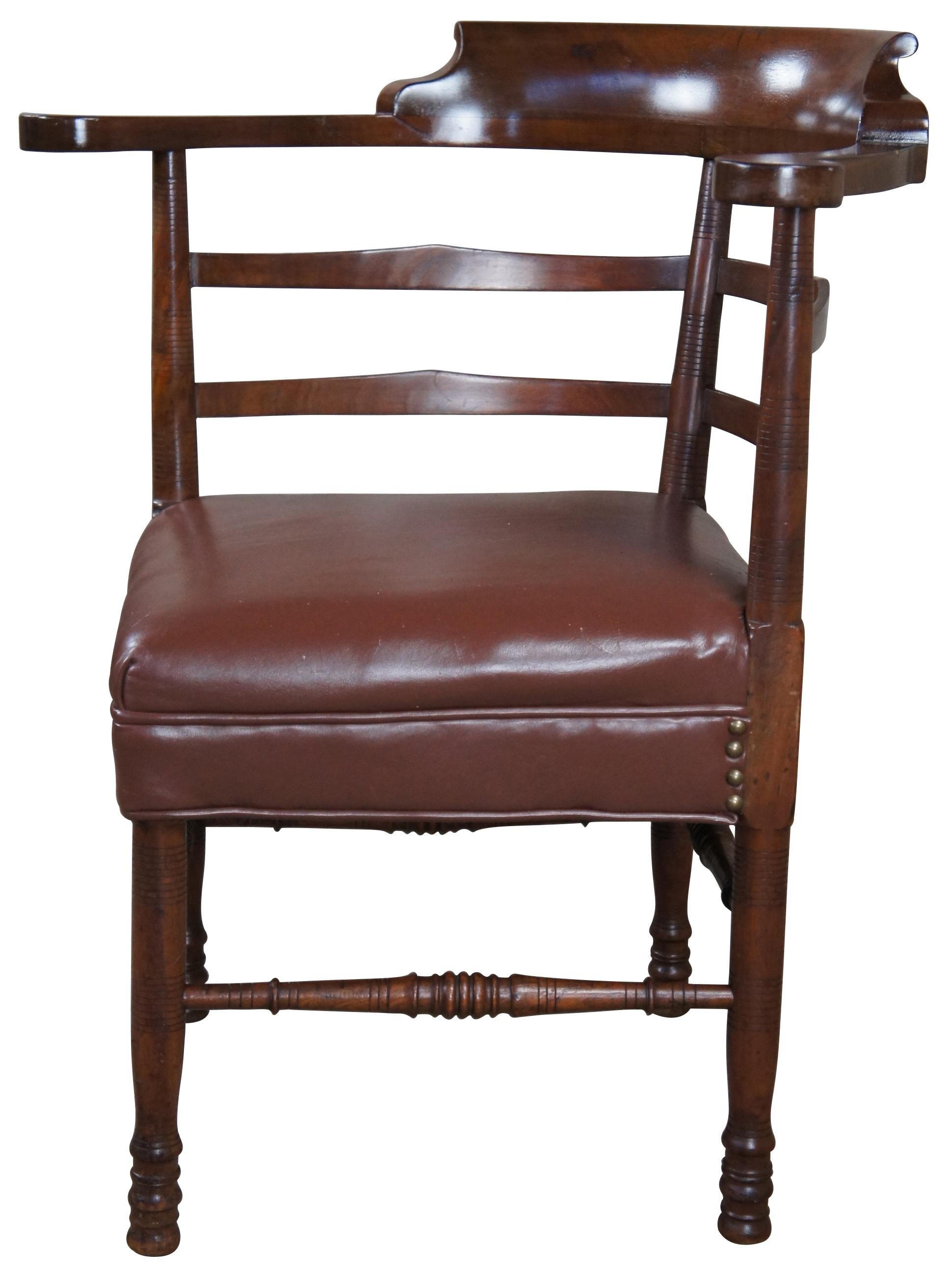 Antique English Country roundabout corner armchair. Made of mahogany featuring rounded form with ladderback supports over turned posts and supports, vinyl seat and nailhead accents.
  