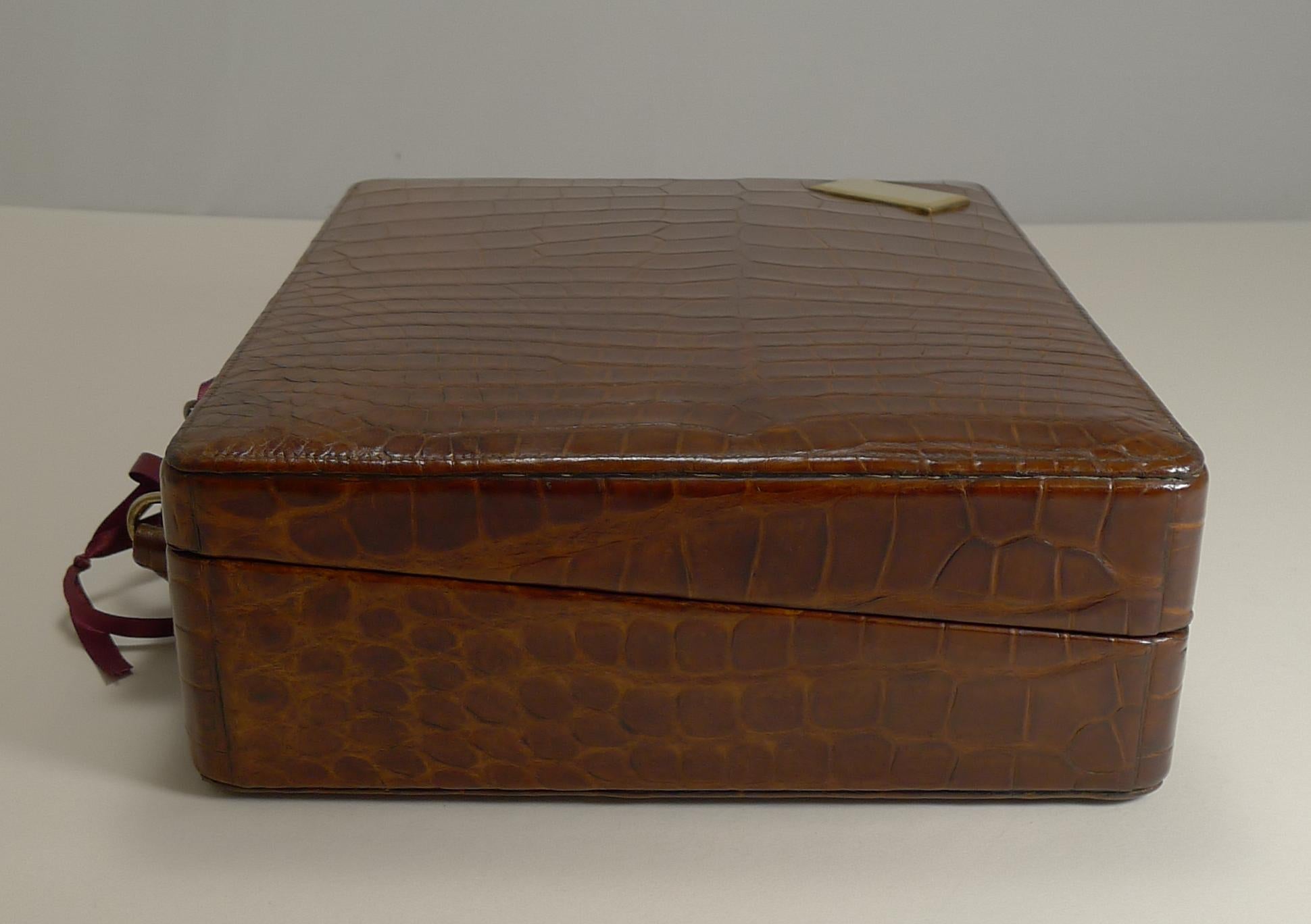 A magnificent late Edwardian jewellery case / box in the form a suitcase covered in rich cognac coloured Crocodile / Alligator skin.

The case has a handle and a polished brass mount, vacant for engraving by your local engraver should you so wish.