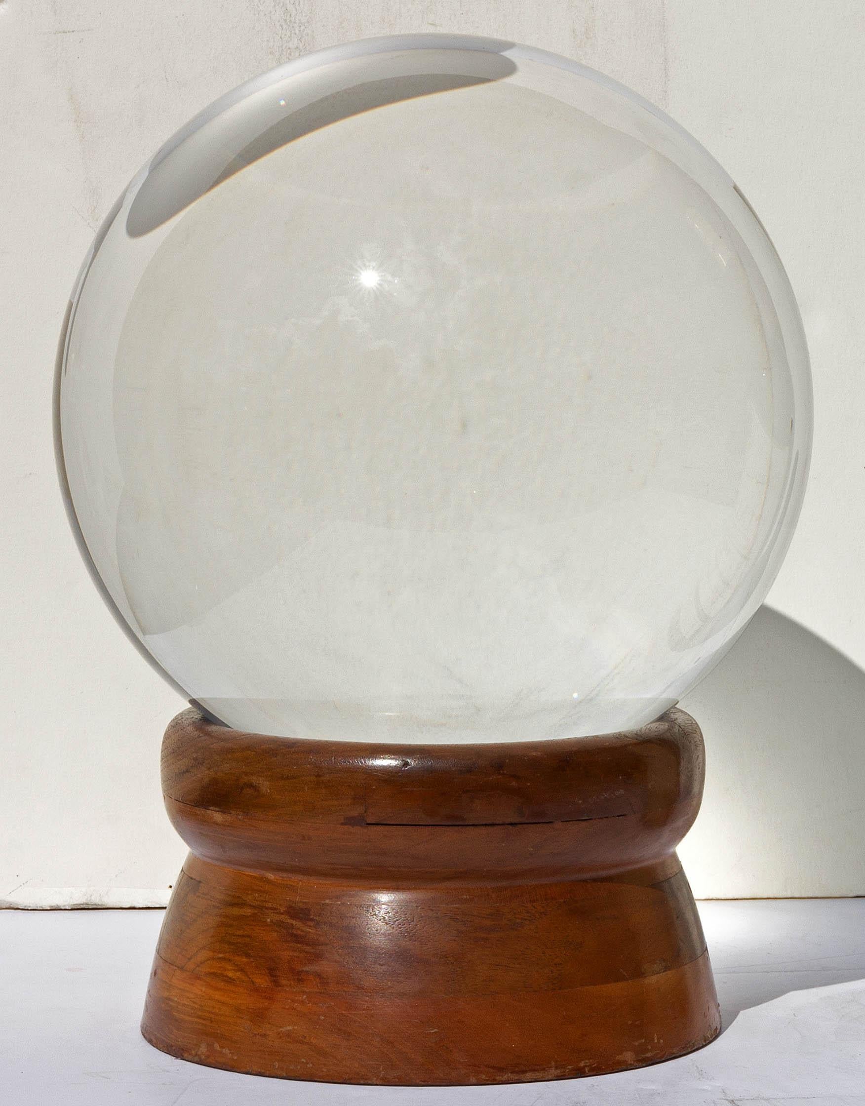 Antique fortune teller's crystal glass ball, early 20th century. Crystal is of the finest quality with no bubbles or inclusions. Turned hardwood base retains original silk velvet pad on underside.