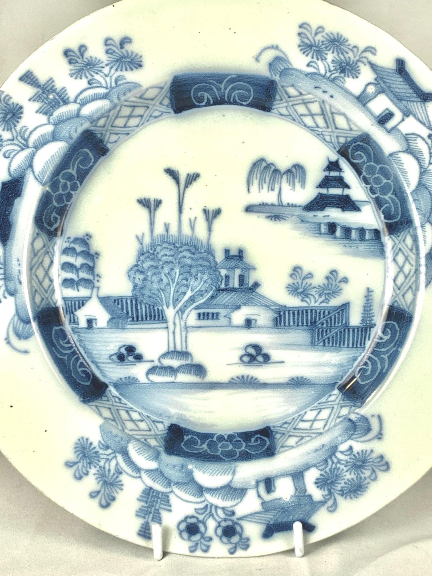 This 18th-century English Delftware plate was hand-painted circa 1760.
The center features a chinoiserie scene depicting the trees that form the 