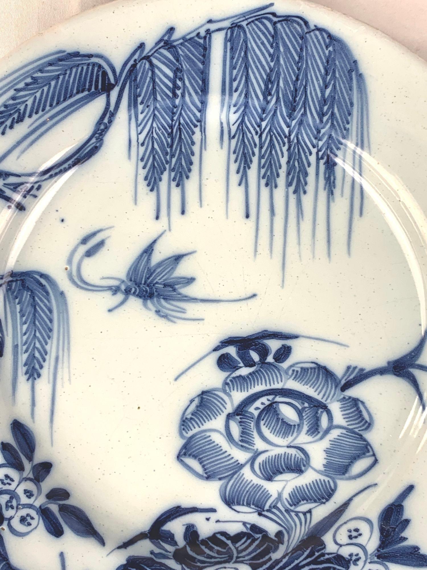 This exquisite blue and white English Delftware plate was hand-painted circa 1760.
The artist captured a fleeting moment in time, featuring a close-up view of a butterfly with its wings outstretched as it floats through the air. Nestled beneath the