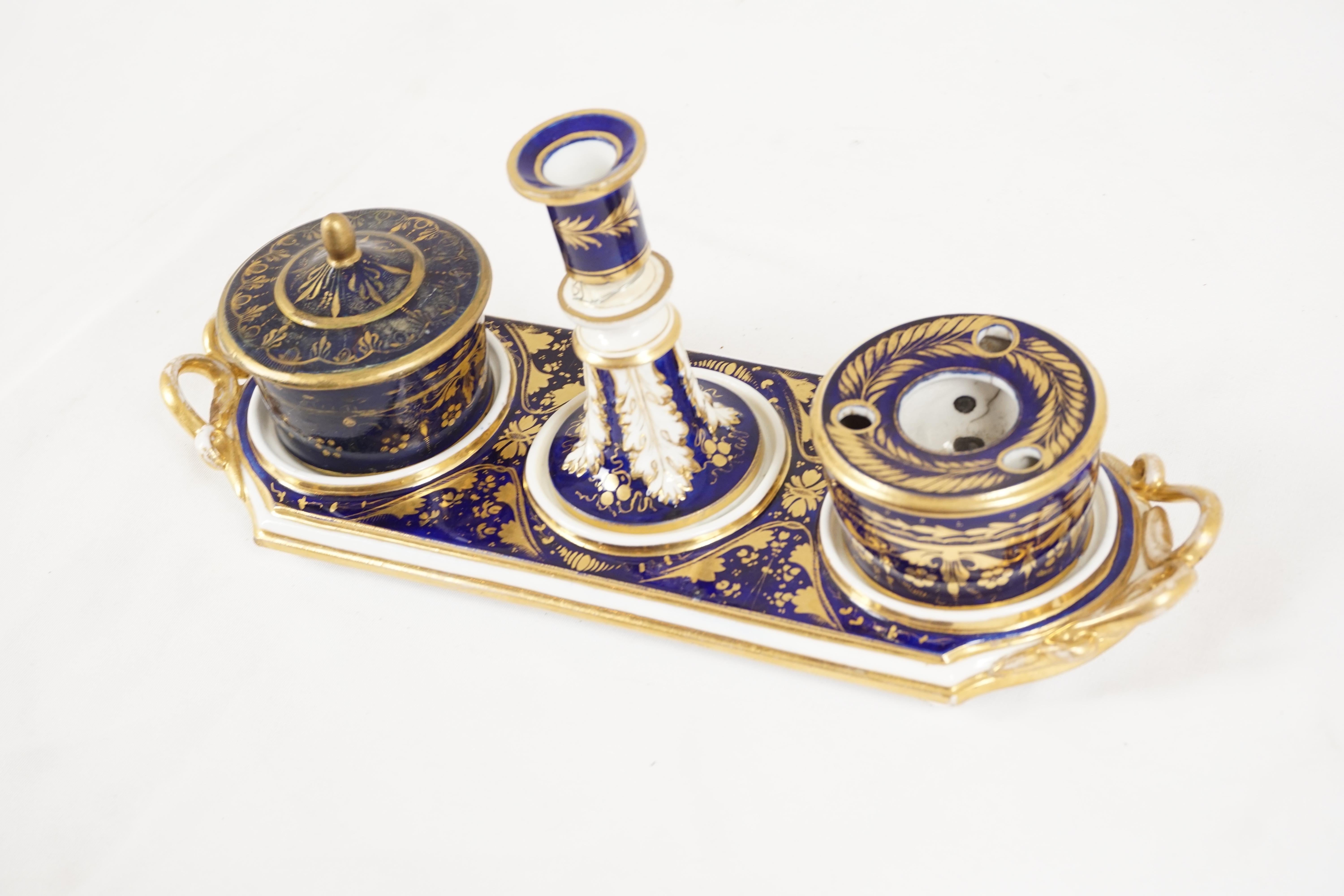 Antique English Derby porcelain ink stand dish on tray, England 1870, H563

Scotland 1870
Tray with blue ground with gilt floral decoration
Single candlestick to the center
Flanked by a porcelain inkwell to the right and to the left a circular stamp
