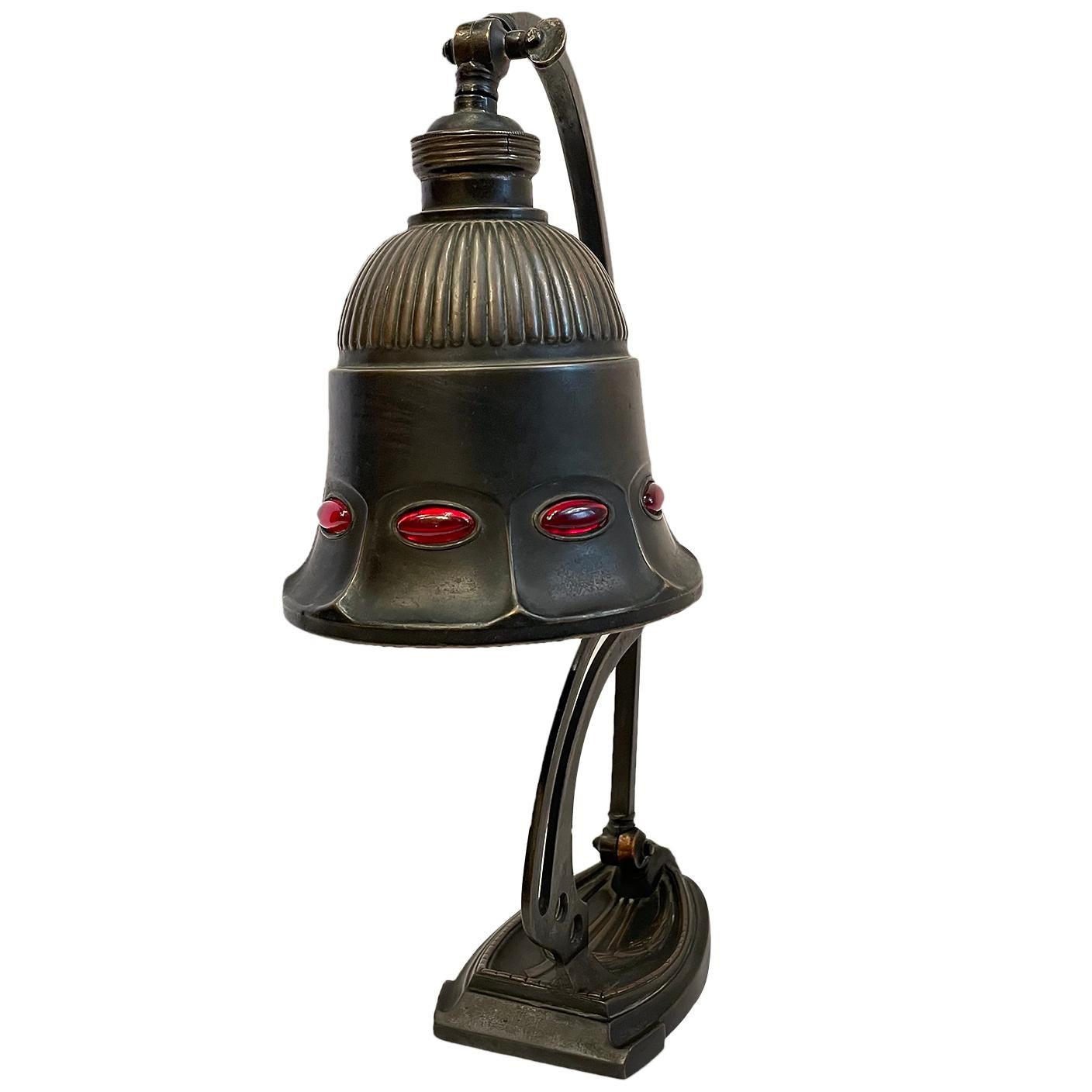 Lampe de bureau ajustable anglaise datant d'environ 1900 avec des inserts en verre rubis.

Mesures :
Hauteur : 14.25
