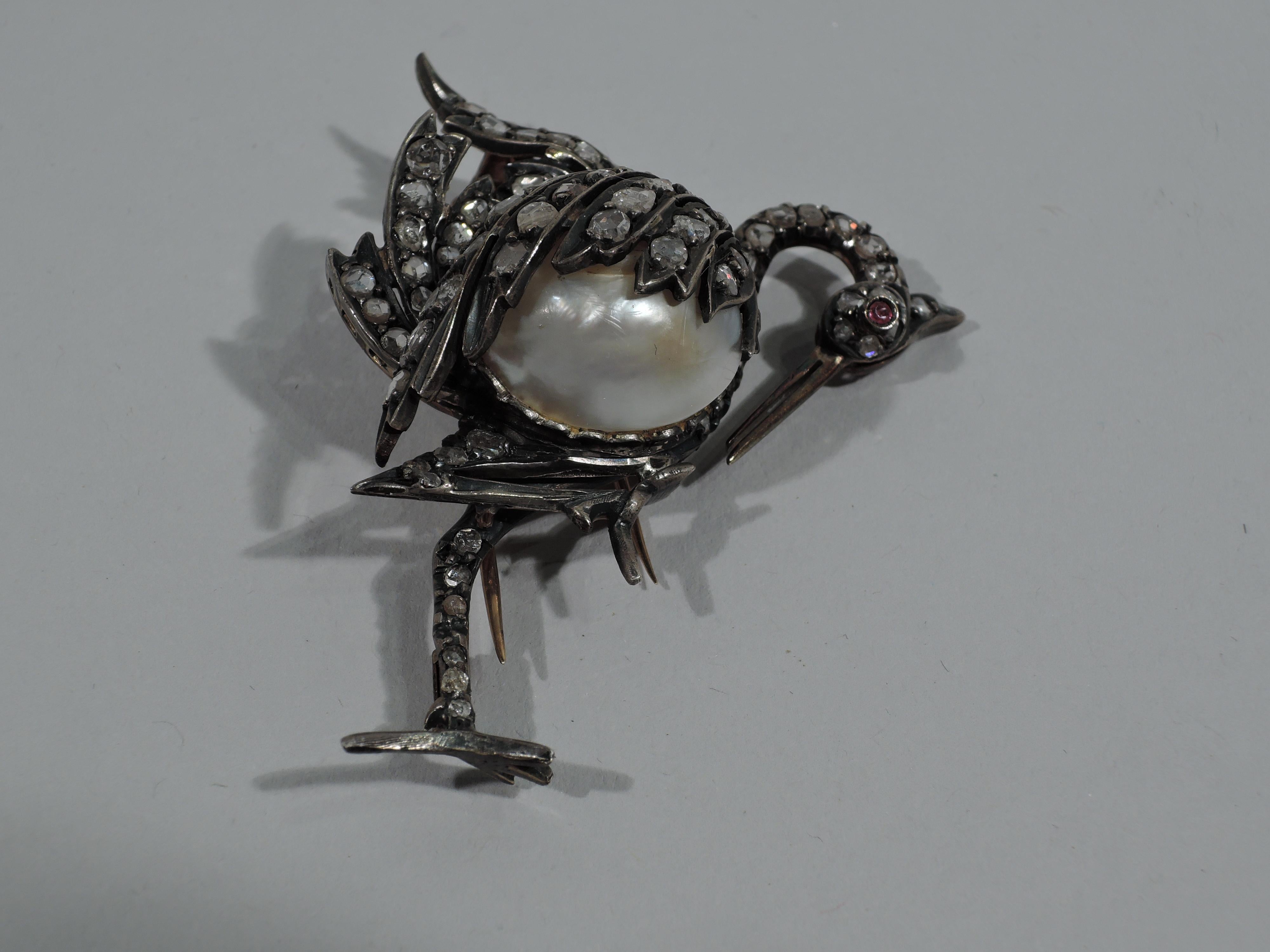 Delightful figural silver brooch in form of stork with natural Baroque pearl body and approximately 100 inlaid rose-cut diamonds. Beak gold and eye cabochon ruby. Gold back. England, ca 1880.  

Dimensions: H 2 1/4 x W 2 1/4 in. Pearl: D (approx.) 1
