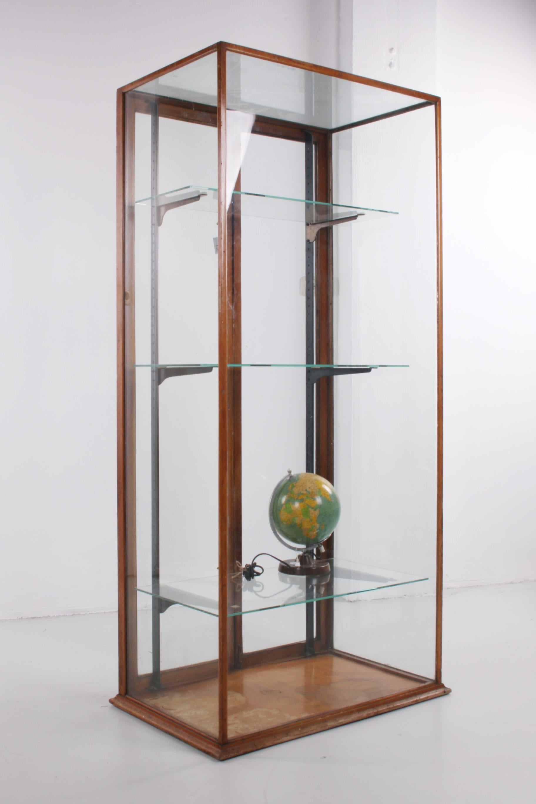 A beautiful display cabinet from England. This one originally comes from one of the better clothing stores in London, where valuable items were often displayed. 

The cabinet has 2 doors at the back, which you can open completely. The frame of the