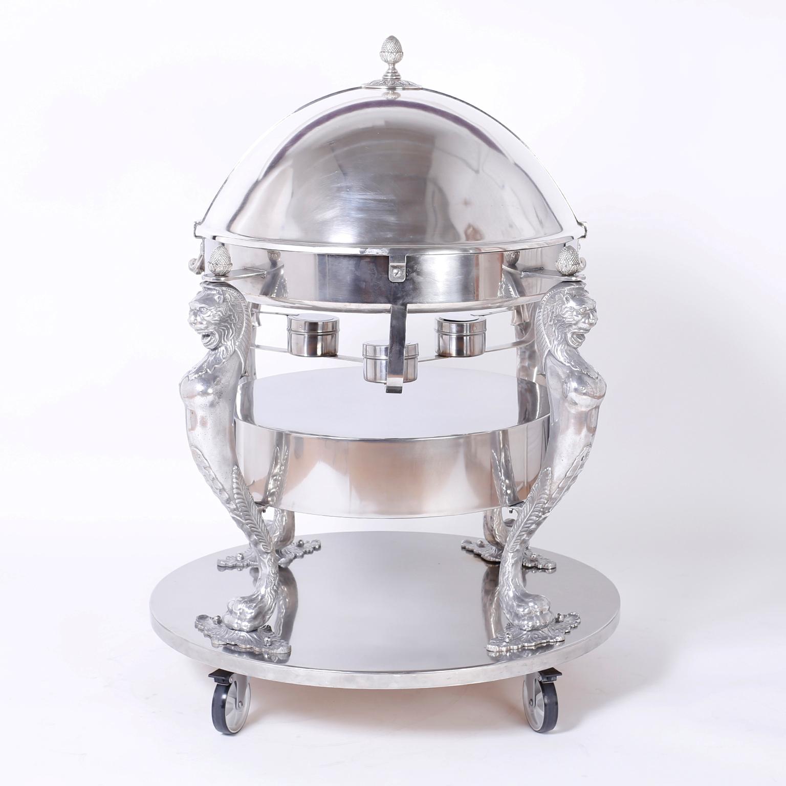 Lavish stainless steel English serving cart with acorn finials, heated service dome supported by four stylized lions ,bun warmer and a classic elegant form. Hand polished, fully functional and stamped Regency Hotel Brooklyn New York.