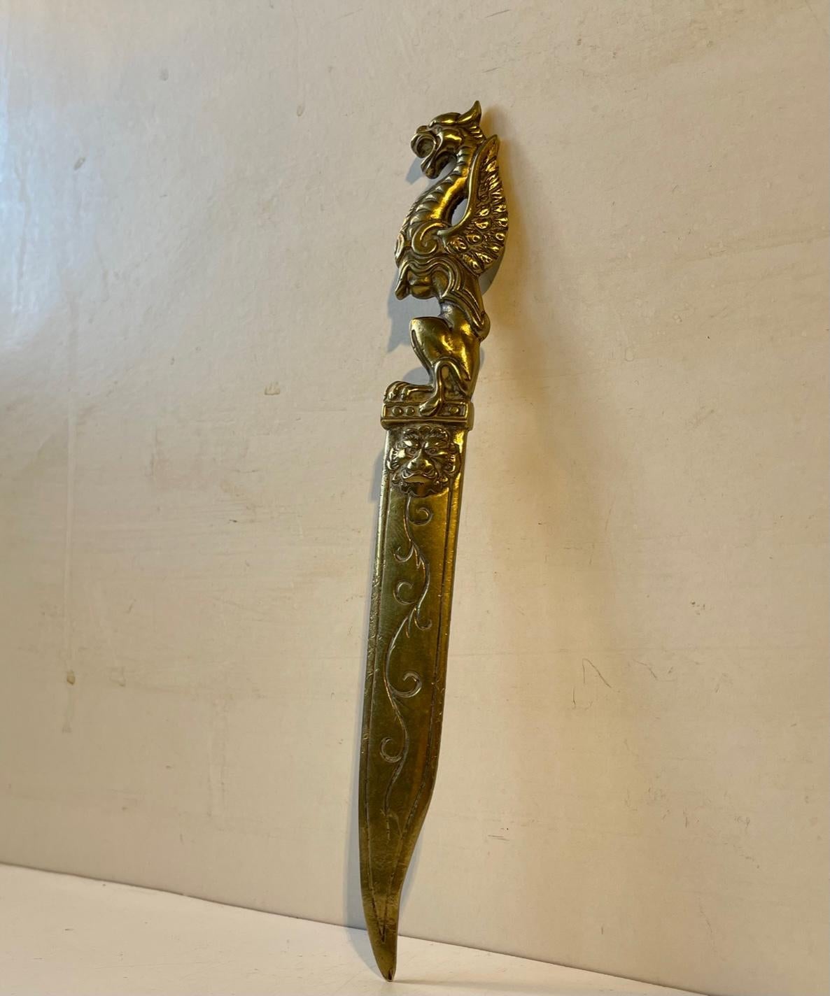 A circa 1920-30 fine quality English brass dragon letter opener or paper knife. It depicts the dragon from the legend of 'St. George and the Dragon'. The lion just below the main ornament represents England. Hollywood regency in style. It is well