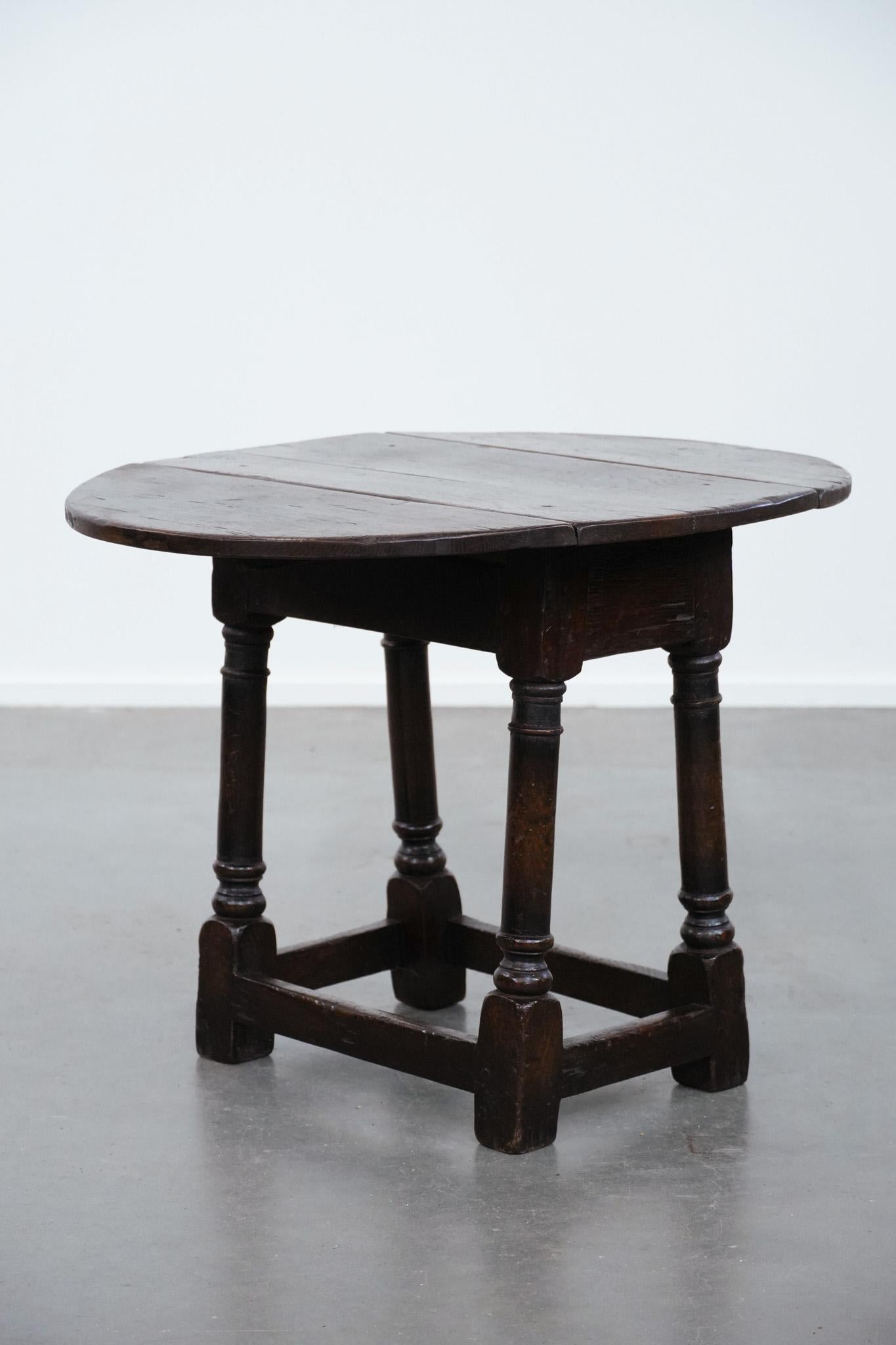 This charming and timeless English antique side table / joint stool comes from the 18th century and is made of oak. This subtle antique item has a beautiful patina and can be easily placed in your chosen space in almost any interior. It is perfect