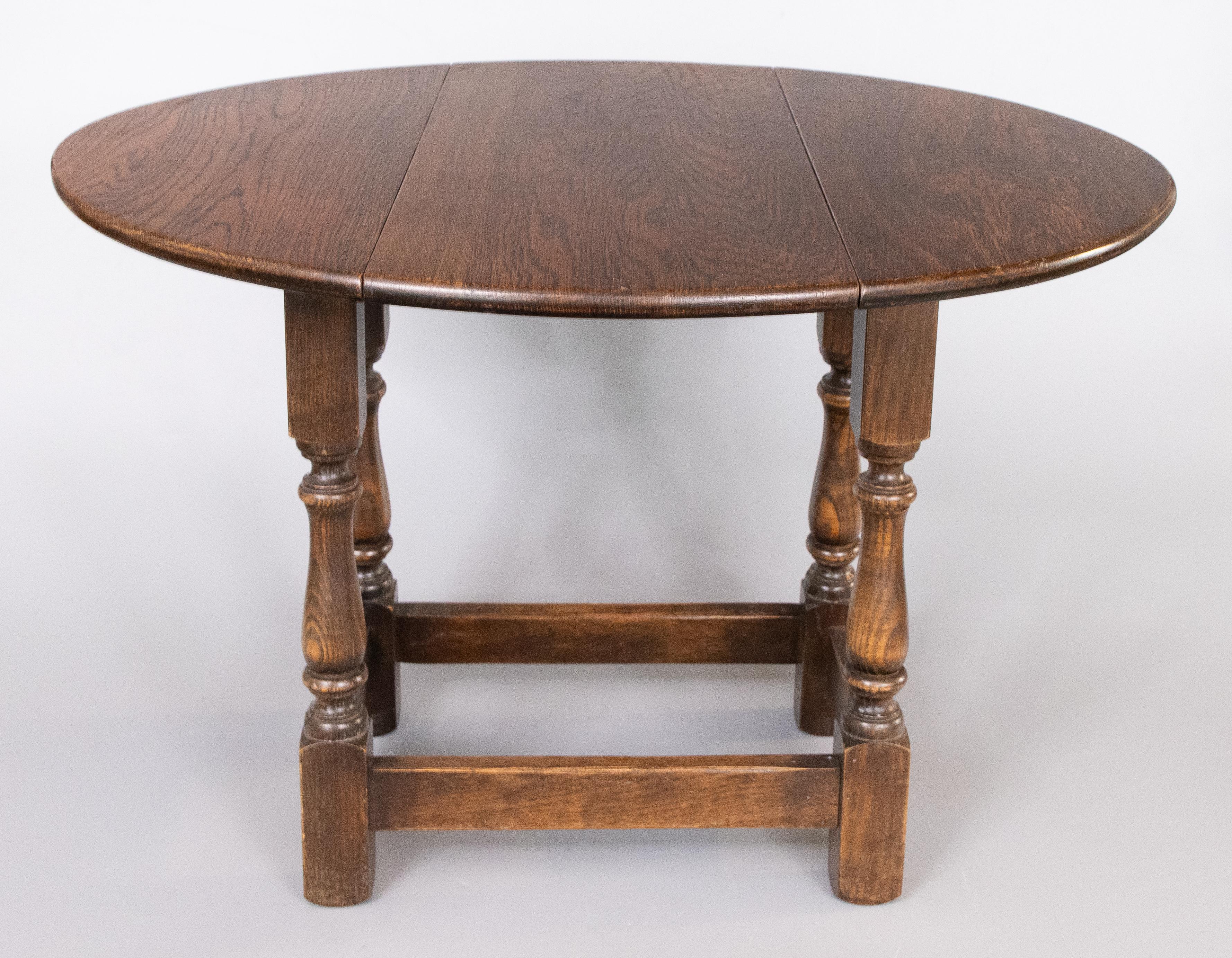 Niedriger Tisch mit drehbarer Platte und klappbaren Blättern auf gedrechselten Beinen, die durch Bahren verbunden sind. Breite des Tischbandes 9,5