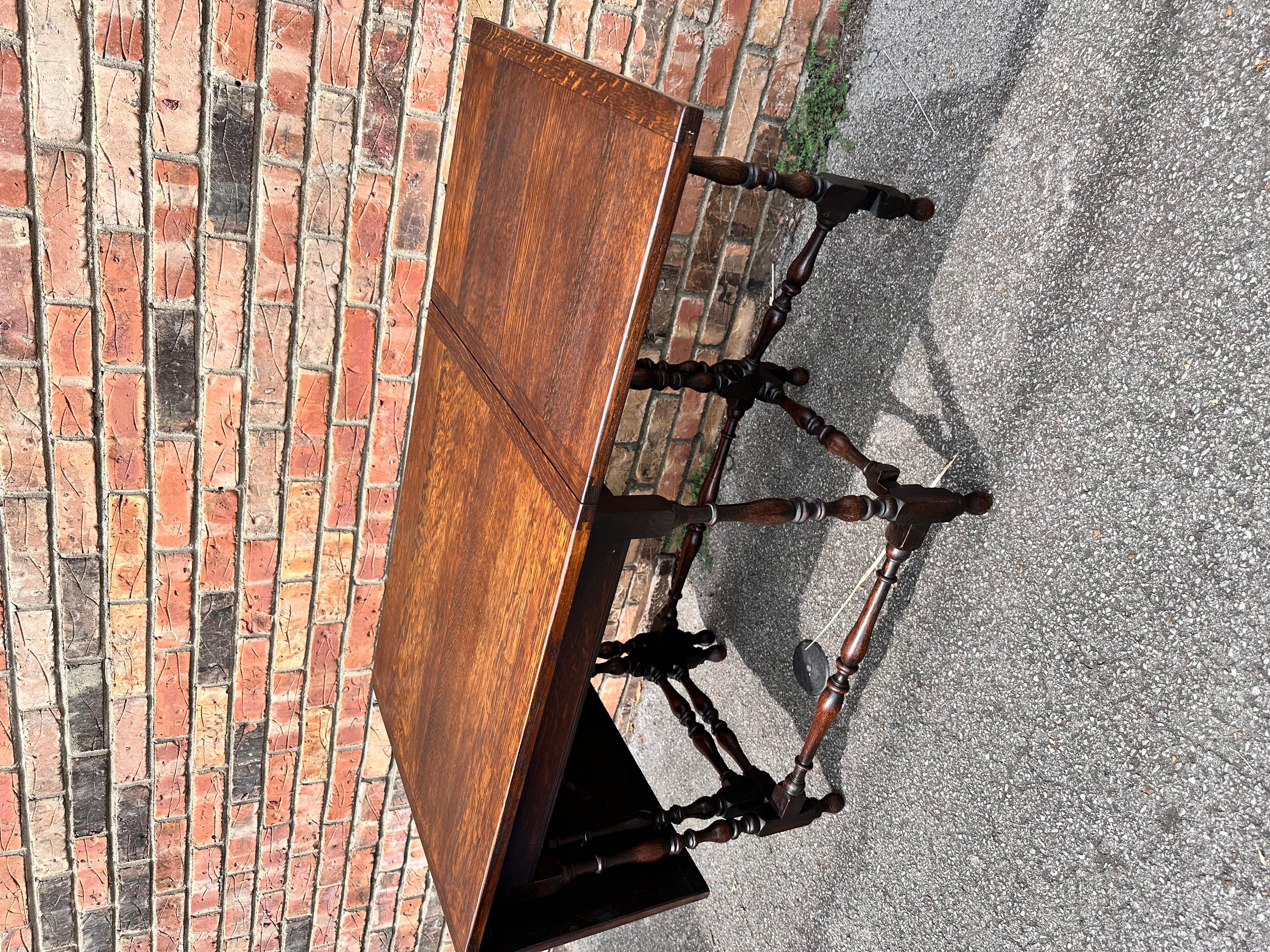 This is a beautiful antique table! Dating to 19th century England, this piece has beautiful character and patina. There is gorgeous variation in the dark toned wood, with natural detail in the grain of the top. The legs are turned, which adds some