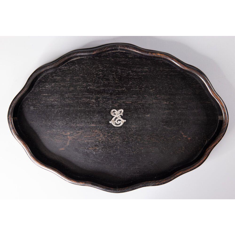 A fine antique English early 20th-Century oval ebony dresser / vanity tray with a serpentine gallery and silver crest in the center. Marked 