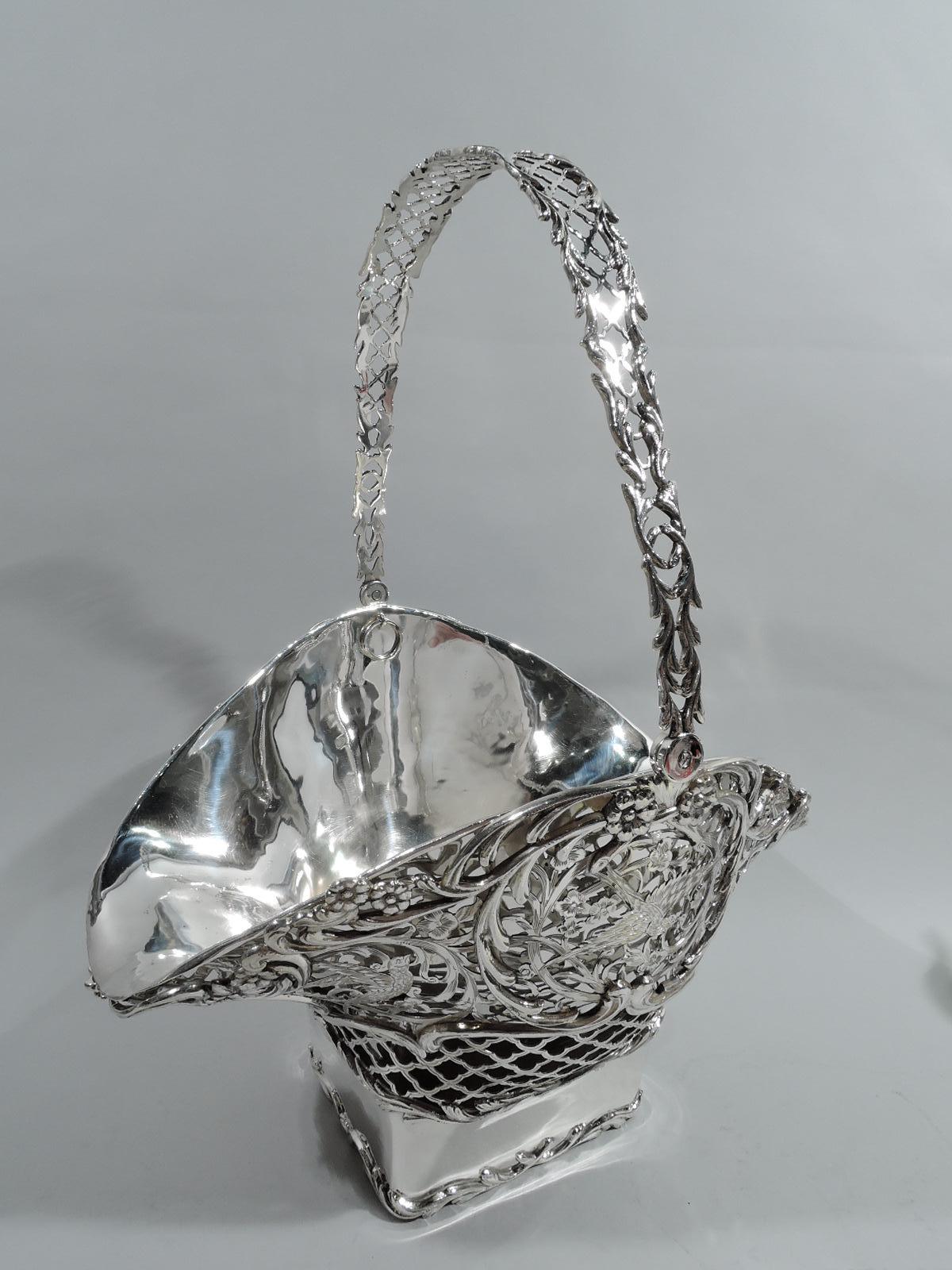 Edwardian Art Nouveau sterling silver basket. Made by William Comyns in London in 1906. Plain and solid square base with applied leafing scroll borders. Sides curved and mouth oval. Open diaper and leafing scrollwork with applied and engraved flower
