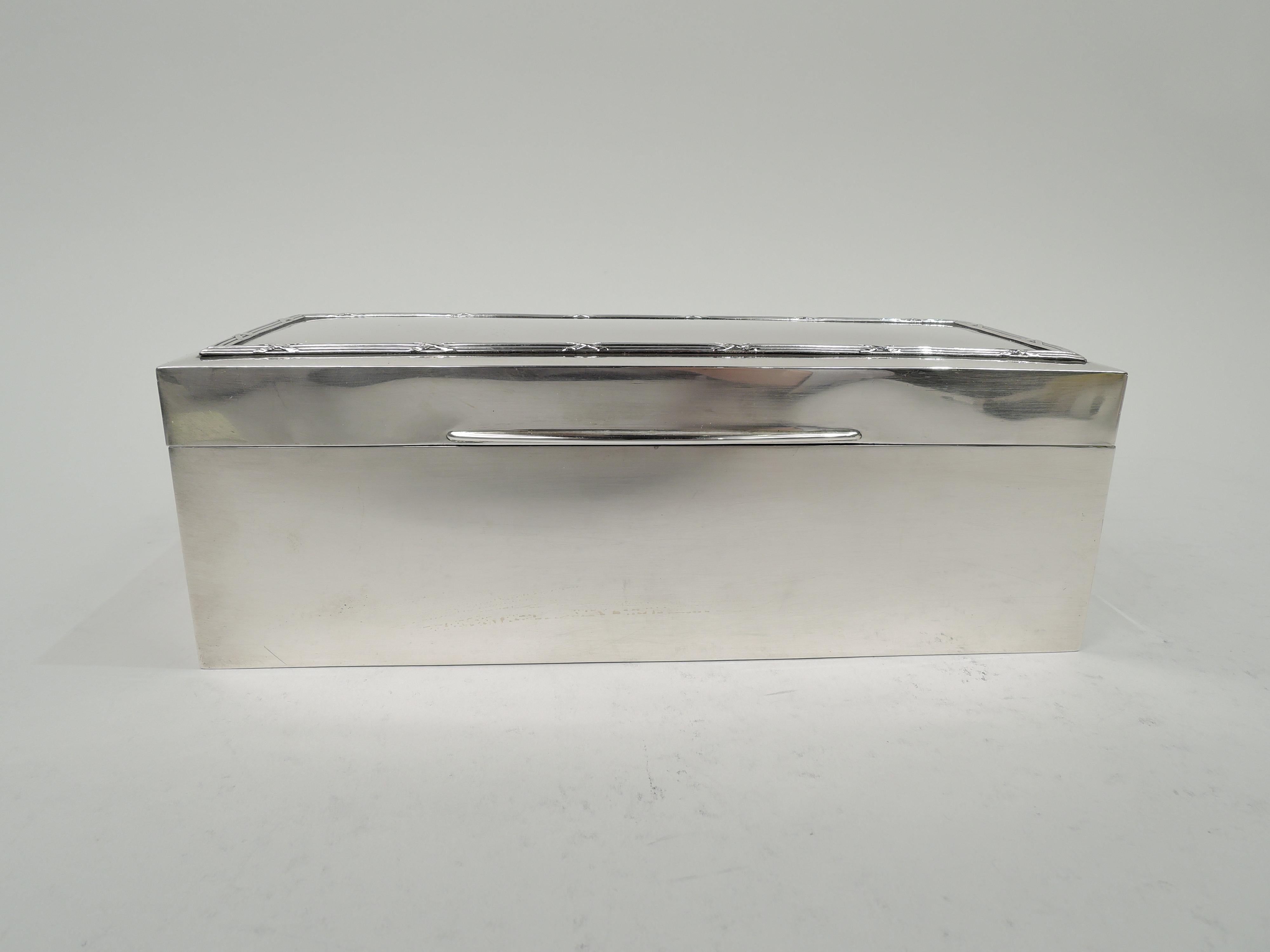 Edwardian classical sterling silver jewelry box, 1909. Rectangular with straight sides. Cover hinged with tapering tab; cover top gently curved with reeded border. Interior silk and velvet lined. Underside leather lined. Fully marked including worn