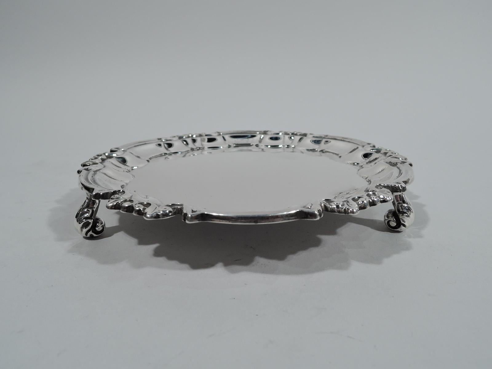 Edwardian Georgian sterling silver salver. Made by William Hutton & Sons, Ltd in London in 1904. Round with 3 leaf-capped volute supports. Molded rim with volute scrolls. Fully marked. Weight: 7.5 troy ounces.