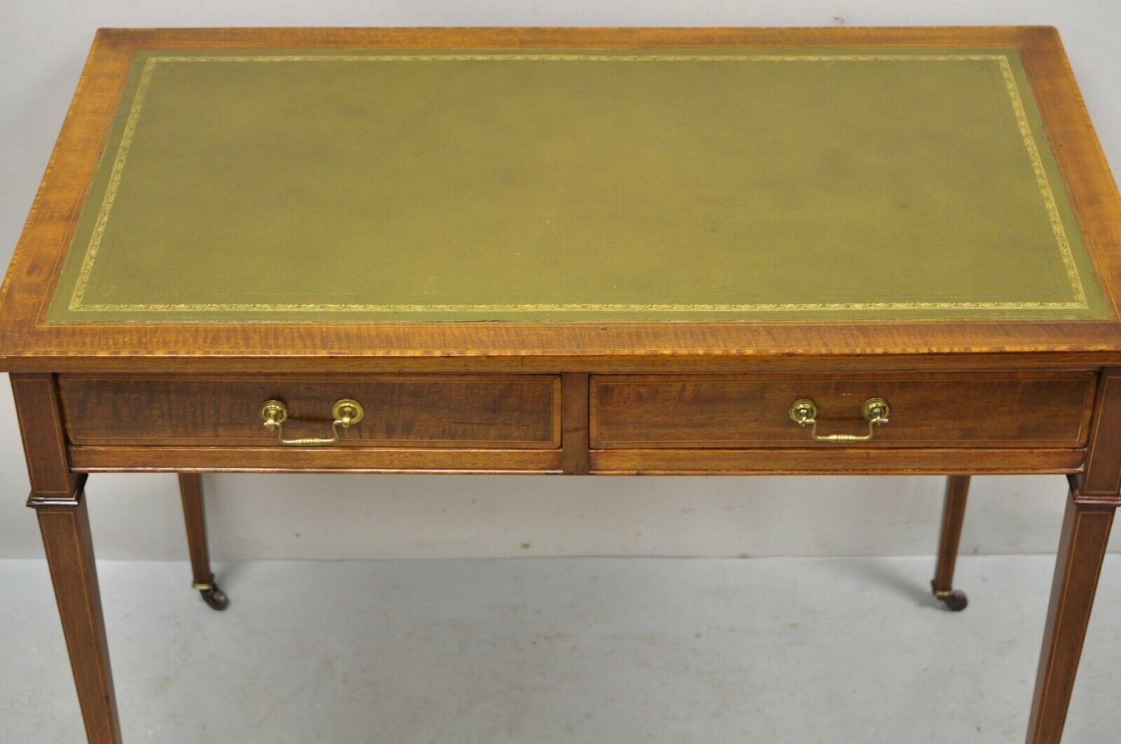 Antique English Edwardian green tooled leather top 2 drawer ladies writing desk. Item features a nice smaller size, green tooled leather gold gilt top, banding and pencil inlay throughout, rolling casters, beautiful wood grain, finished back, 2