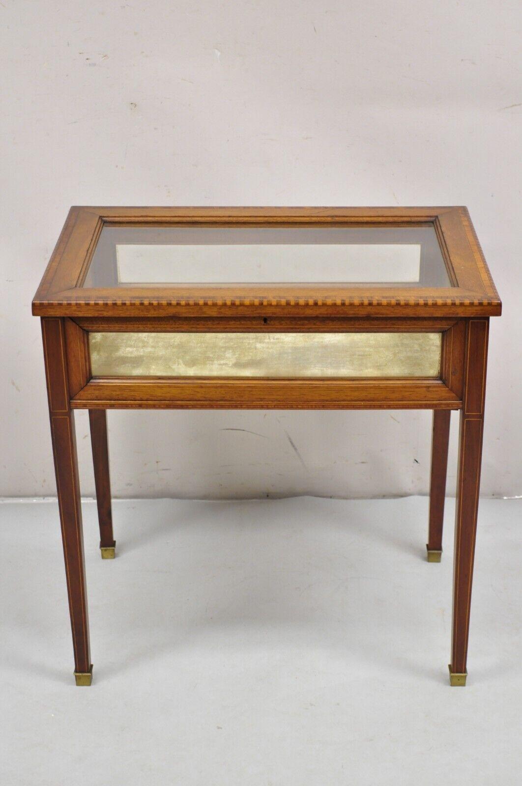 Antique English Edwardian Inlaid Mahogany Small Bijouterie Curio Display Table. Item features satinwood pencil inlay, glass top and sides, fabric lined interior, very nice antique small display table, no key, unlocked. Circa 19th Century.