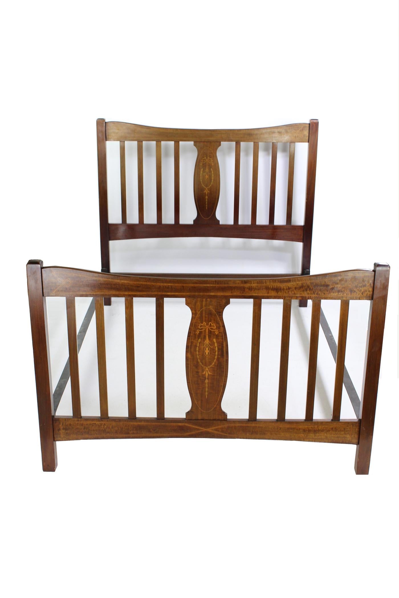 An elegant antique Edwardian mahogany and inlaid double bed dating from circa 1905. In a richly figured mahogany frame, the headboard and footboard inlaid with satinwood inlay. Featuring an inlaid central vase shaped splat flanked by four vertical