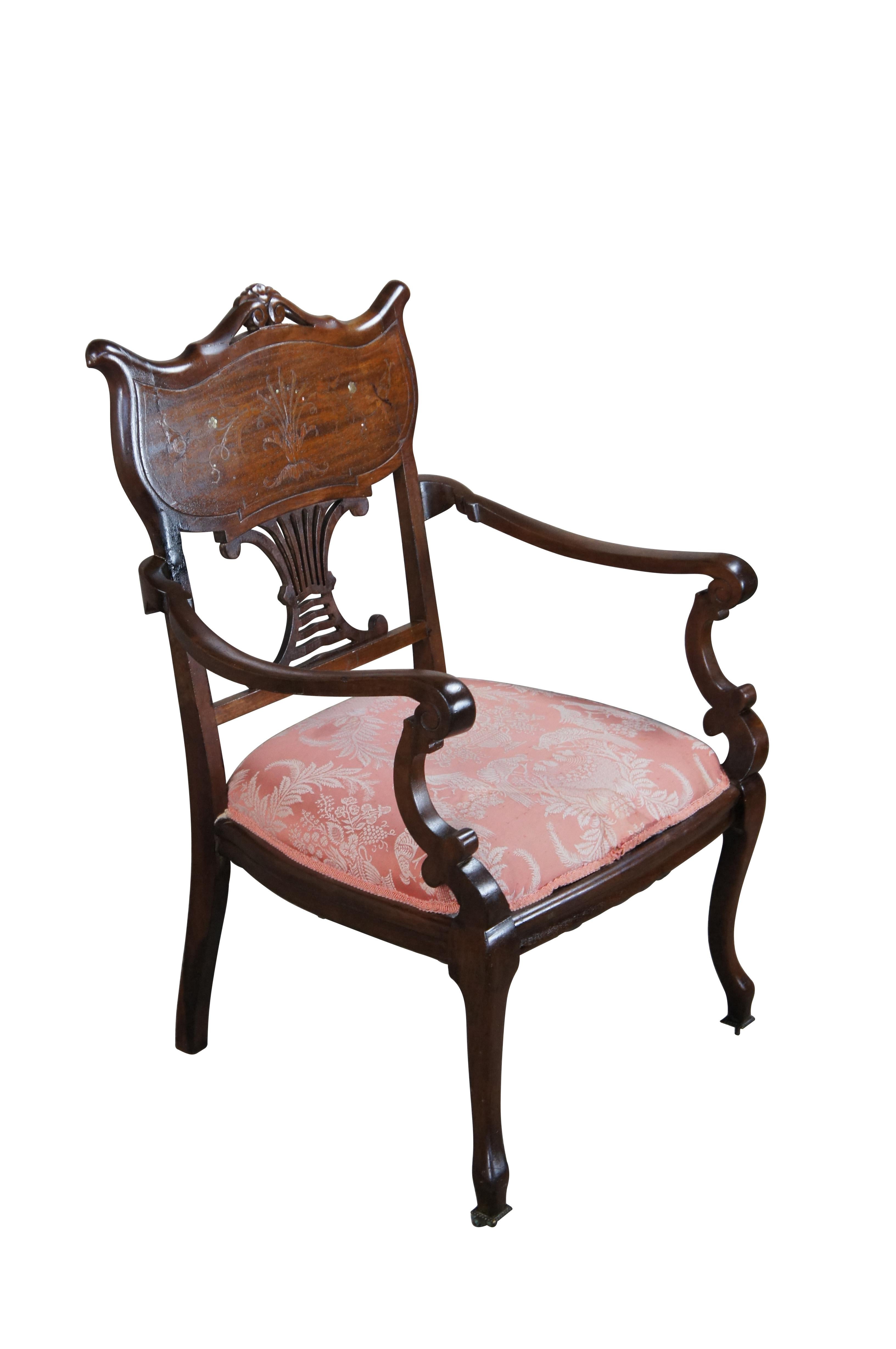 Antique Edwardian parlor accent arm chair.  Made of mahogany featuring shield shaped back with marquetry and mother of pearl inlaid floral acanthus design, pierced support, padded seat and serpentine legs.

Dimensions:
25
