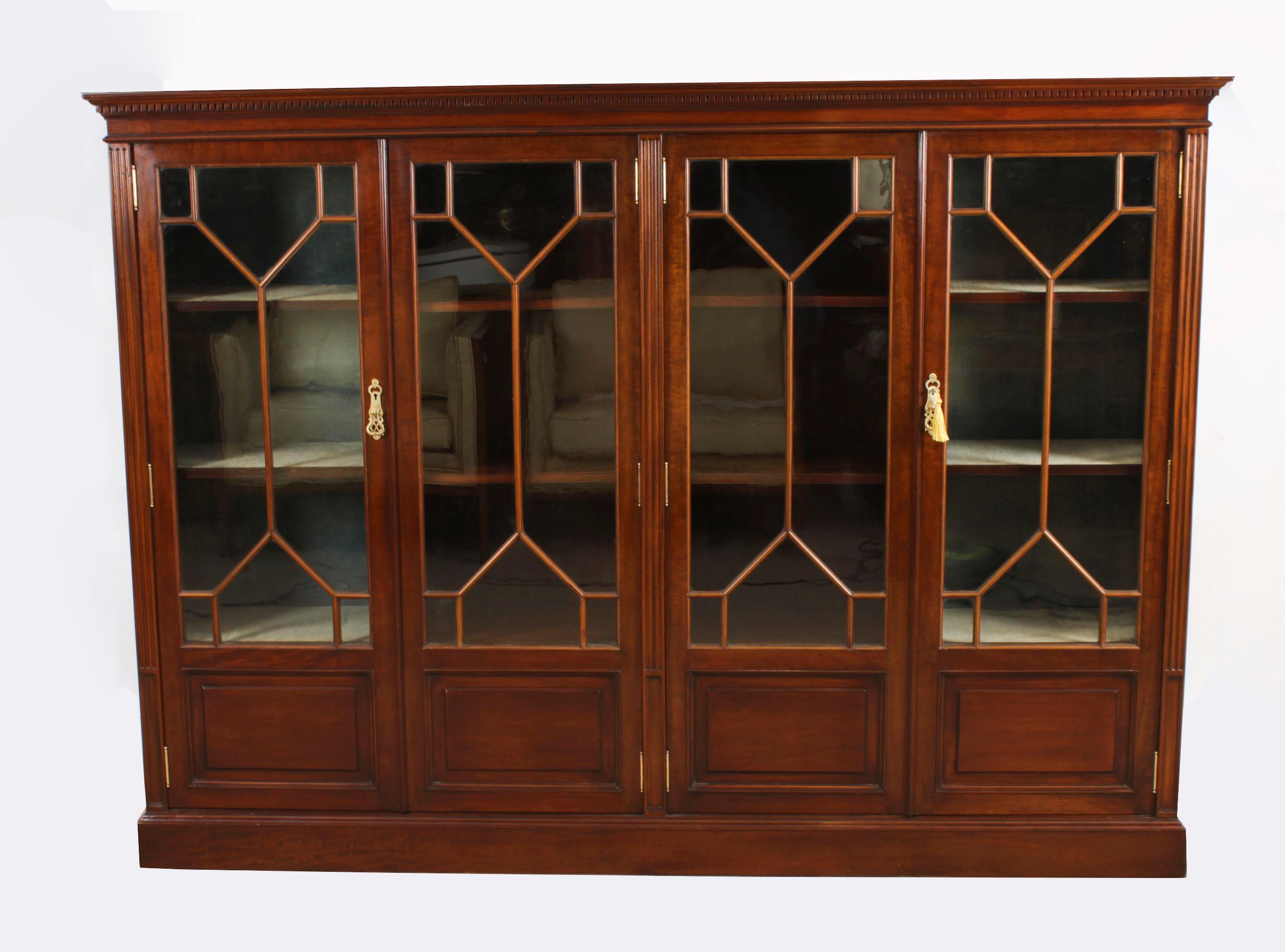 This is a beautiful Edwardian antique mahogany  library bookcase, masterfully crafted in rich solid mahogany, Circa 1900 in date.

The bookcase features  a stepped and cavetto cornice over four astragal glazed doors, the lower part of each is
