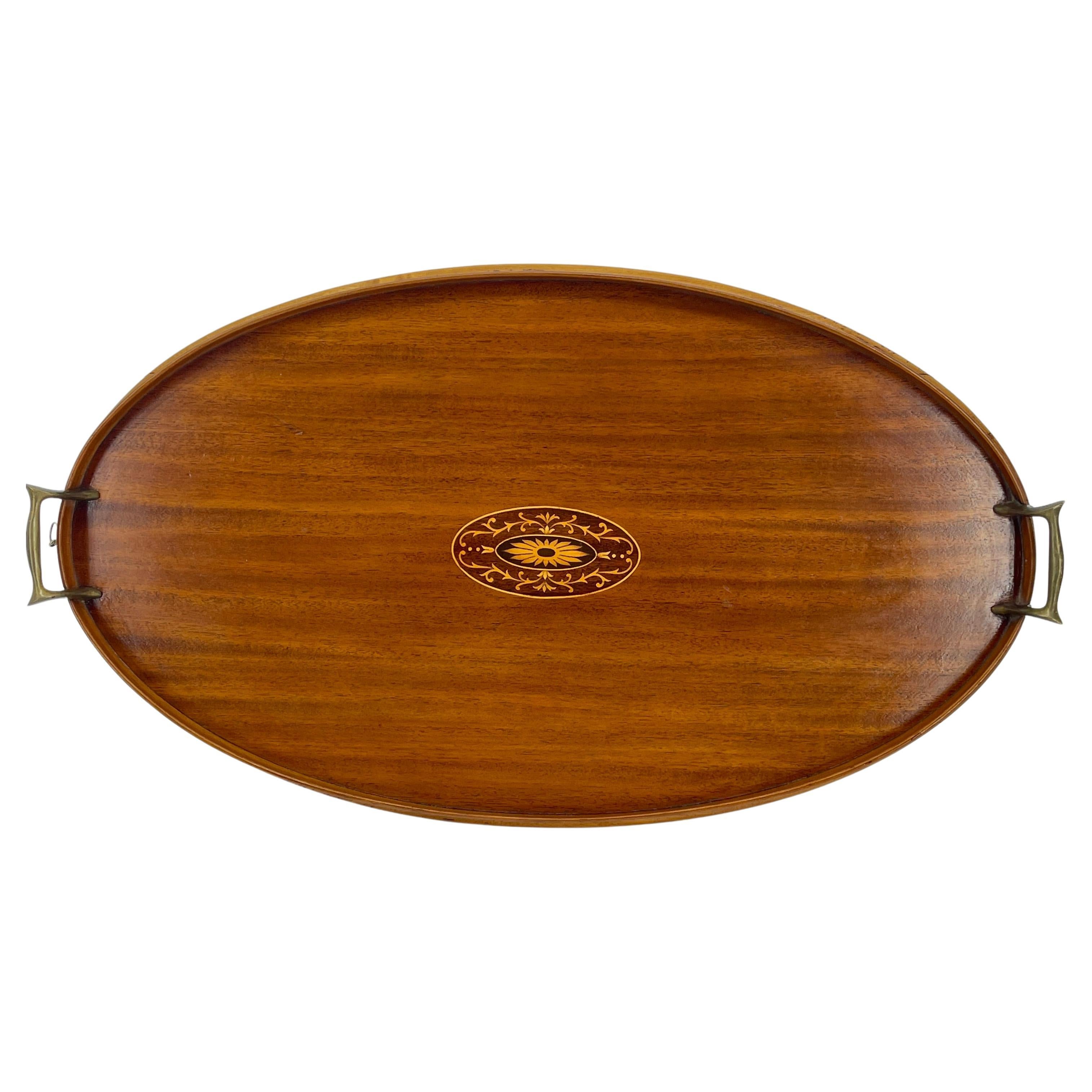 Antique Edwardian English walnut serving tray with inlaid center scrolled and gilded design. The elegant serving tray is as comfortable serving cocktails as it is proper afternoon tea. The center inlay design of the oval tray is gorgeous and