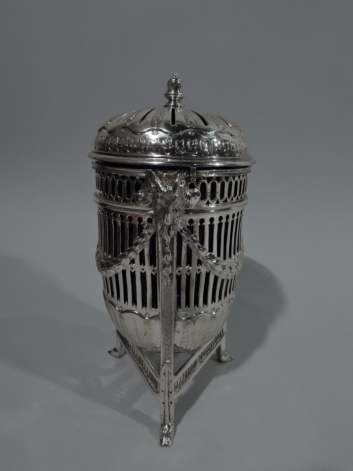 Edwardian Neoclassical sterling silver potpourri. Made by George Nathan & Ridley Hayes in Chester in 1904. Ovoid urn in tripod frame with ram’s head monopodium supports and pierced stretchers. Pierced sides and base fluting. Cover domed and pierced
