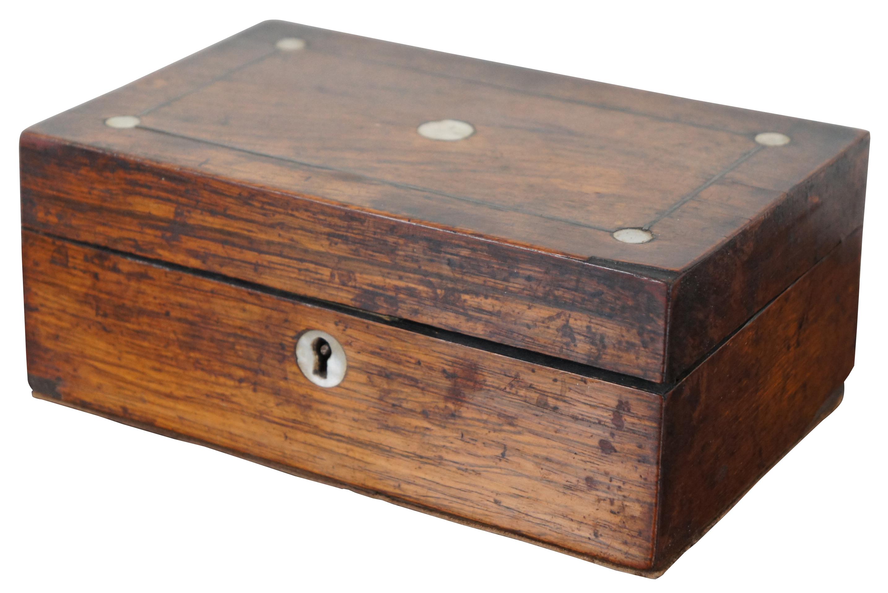 Antique English Ewardian oak trinket or keepsake box with inlaid mother of pearl discs on the lid, red silk lining and added leather padding to interior and base. Measures: 8”.
  