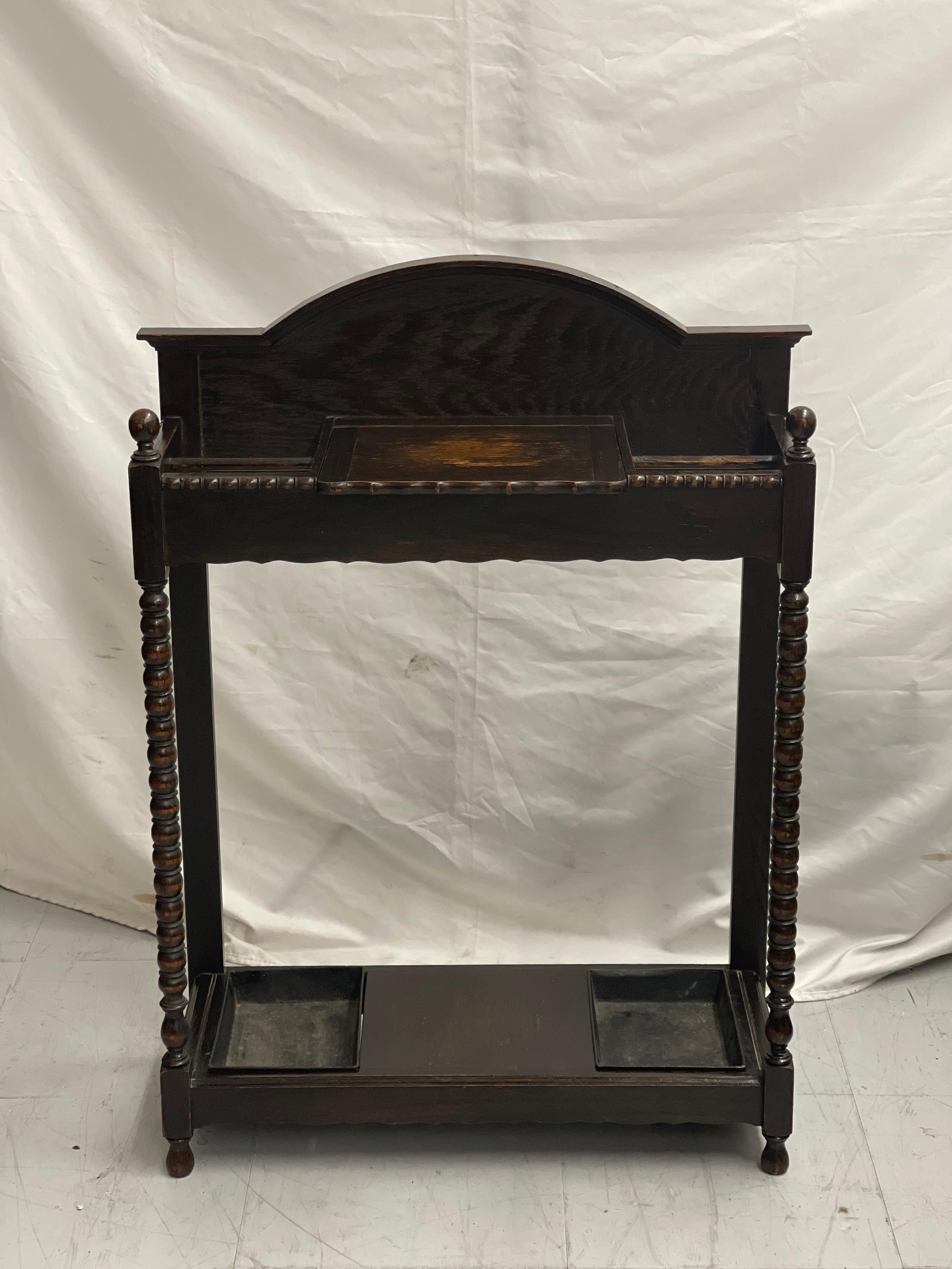 This is a good quality antique English Edwardian solid oak stick & umbrella hall stand, with a pair of tin drip trays, circa 1910, in excellent original condition.