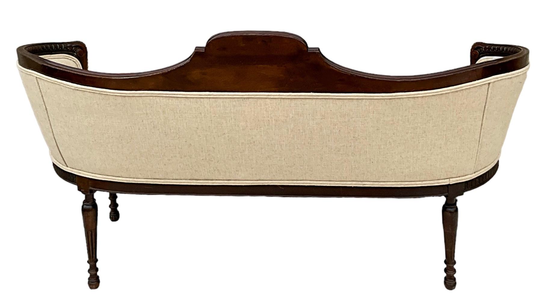 Das ist so ein schönes Stück! Es handelt sich um ein antikes geschnitztes und vergoldetes Mahagoni-Sofa. Es hat ein hübsches gemaltes Medaillon, das zwei Puttis darstellt. Die Polsterung aus hafermehlfarbenem Leinen ist neu. Es ist nicht