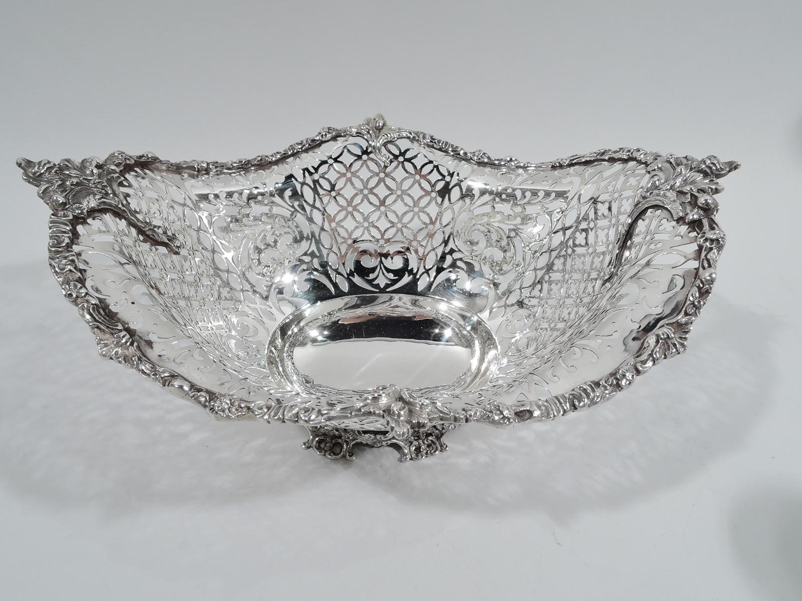 George V sterling silver bowl. Made by S. Blanckensee & Son Ltd in Birmingham in 1918. Solid oval well and tapering sides with pierced and open quatrefoils, scrollwork, and flowers. Wavy rim with tooled flowers, leaves, and scrolls; large stem