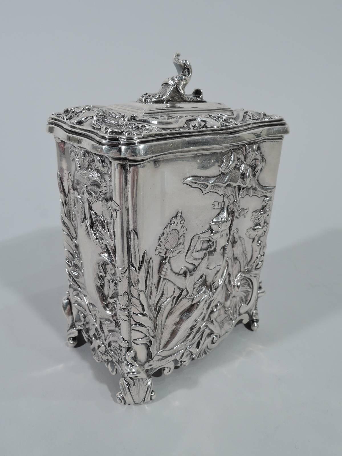 Edwardian sterling silver tea caddy. Made by George Fox in London in 1909. Shaped and rectilinear with corner scrolled bracket feet and hinged cover with finial. Chased and repousse ornament. On front and back, a bosomy lady is shaded by a parasol