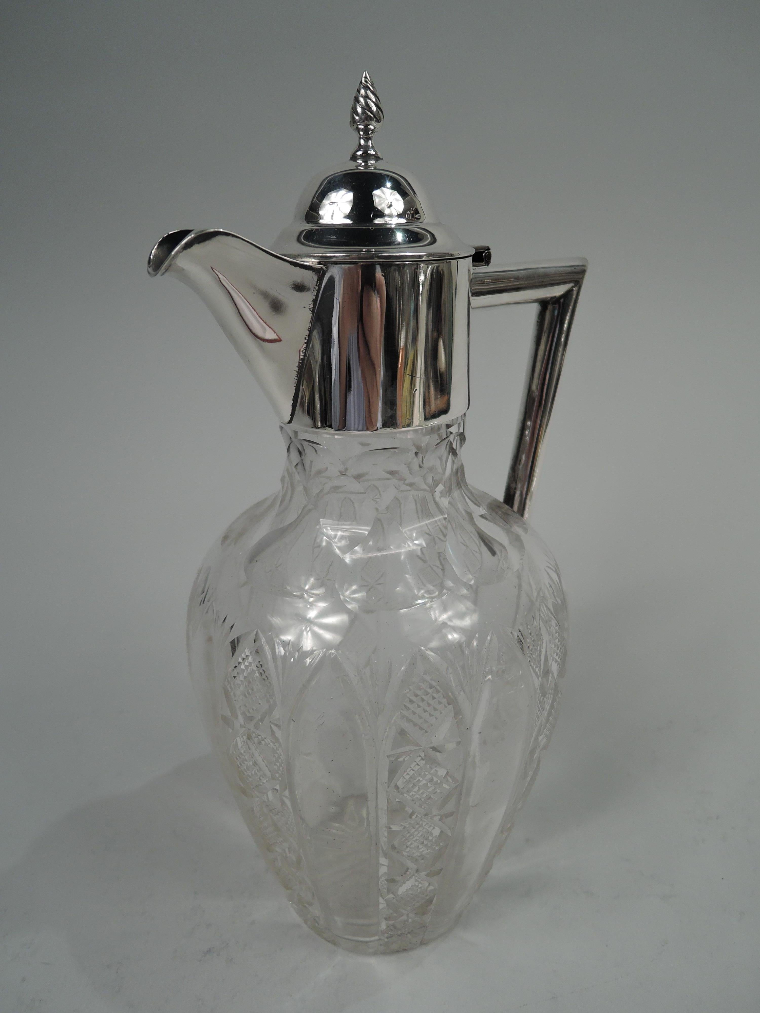 Edwardian sterling silver and cut-glass decanter. Made by William Aitken in Birmingham in 1902. Ovoid glass bowl. On sides plain flutes alternating with diaper flutes; shoulder has shaped facets. Straight neck with sterling silver collar and hinged