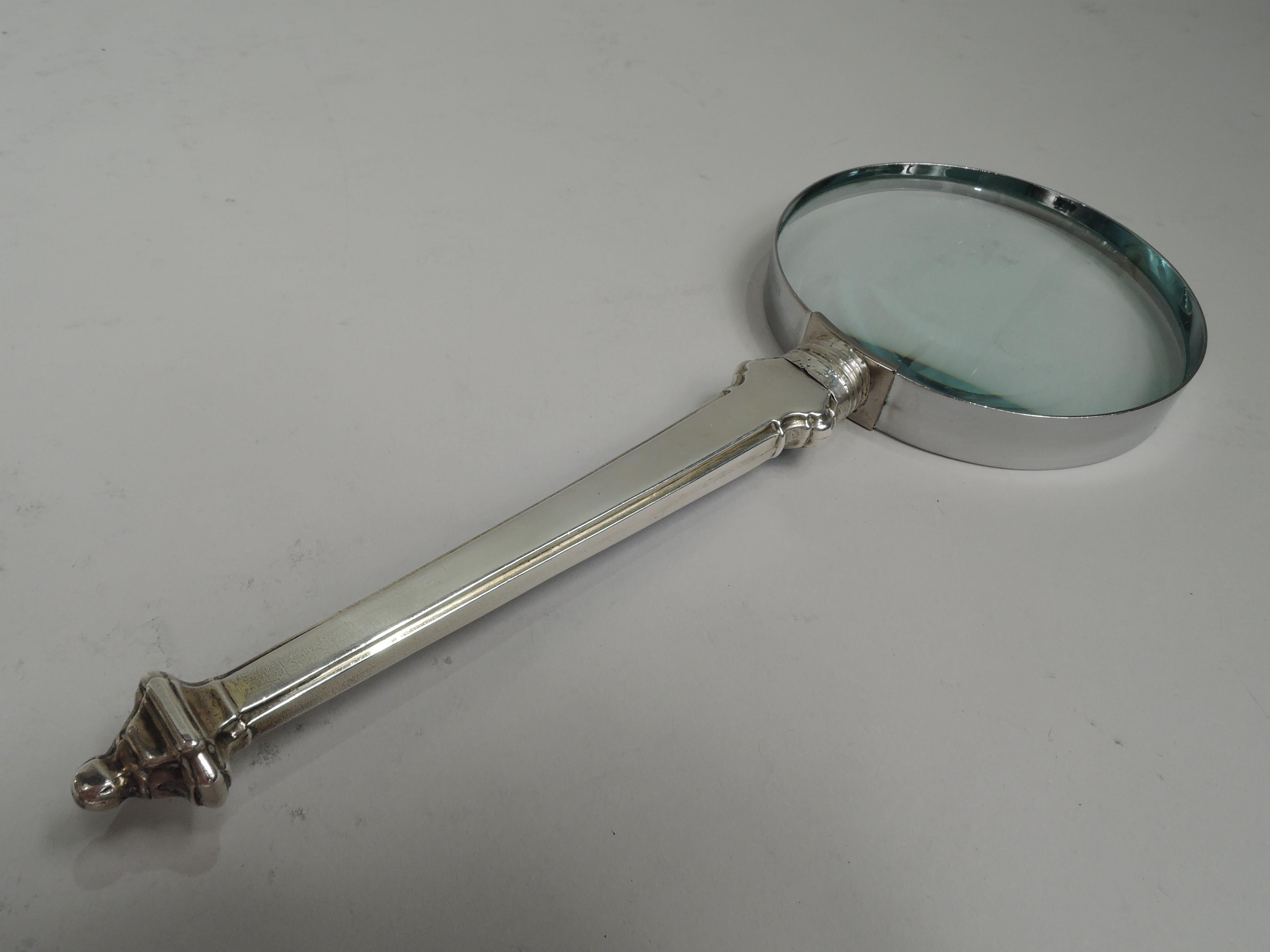 English Edwardian sterling silver and enamel magnifying glass, 1910. Tapering handle with vasiform finial and blue guilloche enamel on front; back plain. Round lens in metal frame. Handle has English marks including Sheffield assay stamp and worn