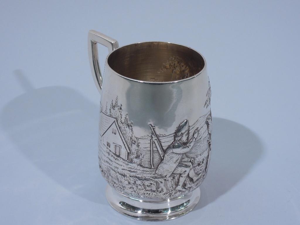 Edwardian sterling silver baby cup. Made by Francis Higgins in London in 1907. Upward tapering sides, raised and spread foot, and scroll bracket handle. Chased scene with countryman reaching out to a perched bird with cottage a picket fence in