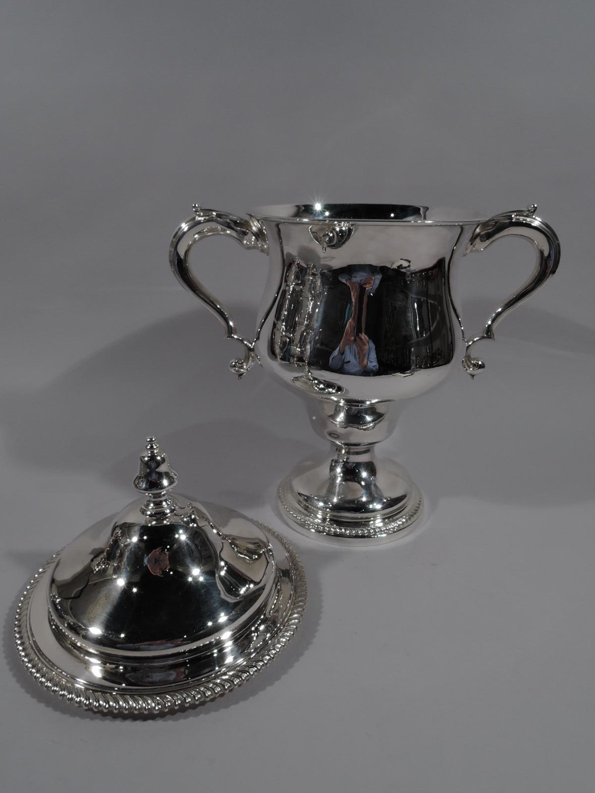Edwardian sterling silver Classical covered urn. Made by Martin, Hall & Co. Ltd in Sheffield in 1904. Deep and wide-bodied baluster with leaf-capped double-scroll side handles and domed foot. Cover domed with acorn finial. Gadrooned rims.