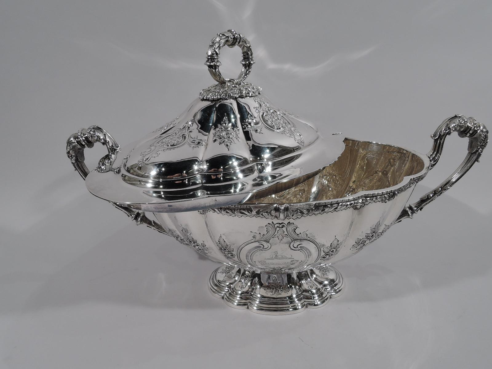 Edwardian sterling silver soup tureen. Made by Martin, Hall & Co. in Sheffield in 1908. Ovoid with lobed body on raised and lobed and stepped oval foot. High-looping leaf-wrapped reeded side handles. Cover domed and lobed with wrapped ring finial.