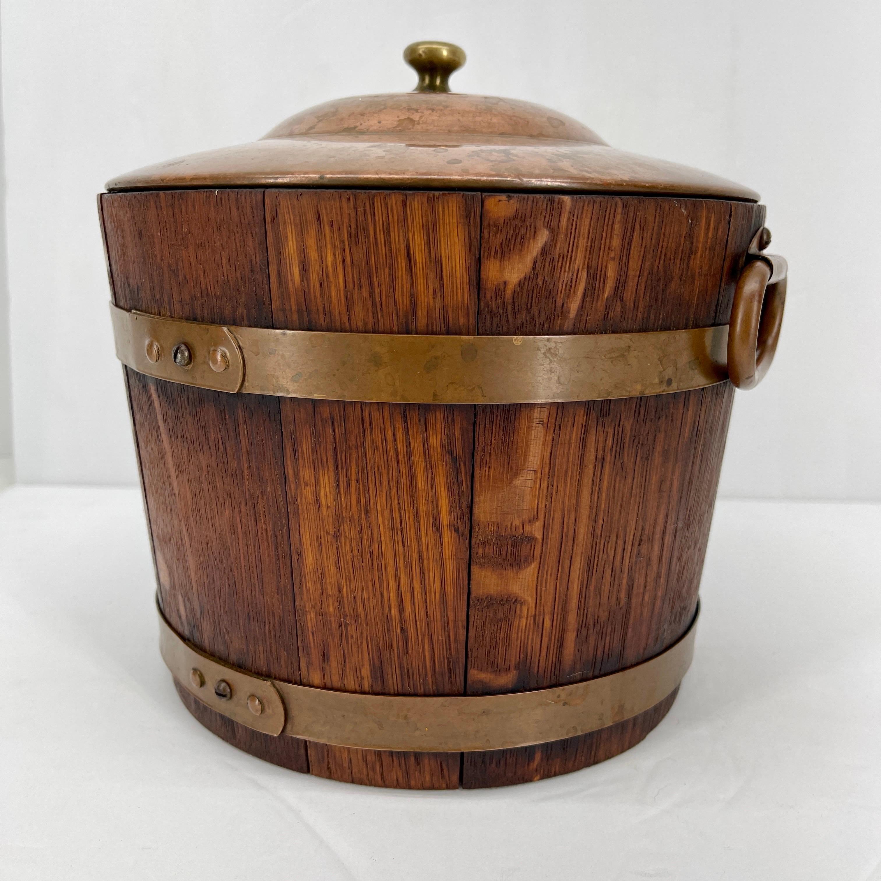 Charming English oak ice bucket with brass double banded accents and handles.
The ice bucket has the original mirror glass insert for better keeping the ice cubes cold.