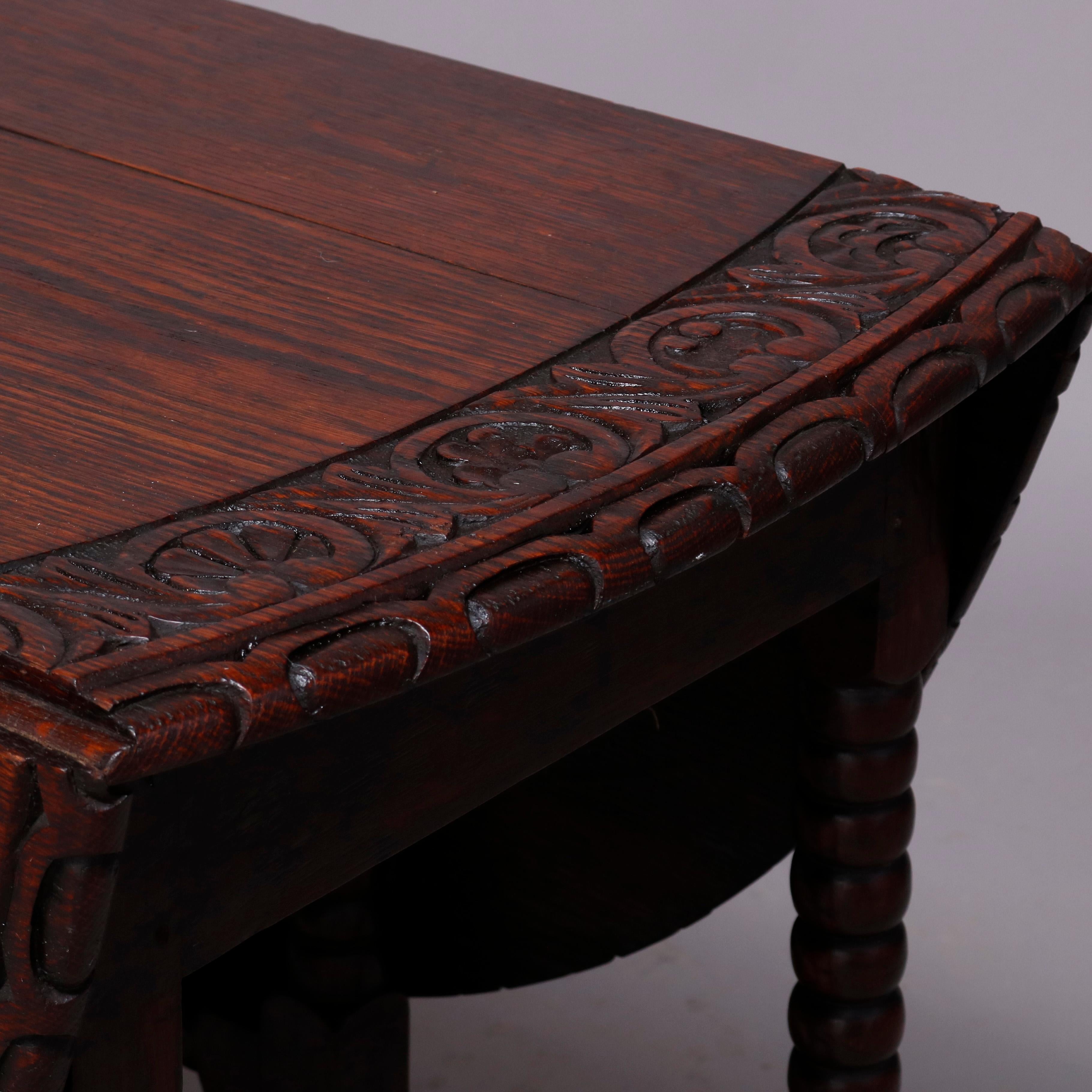 An antique English Elizabethan drop leaf dining table offers top with deeply carved scroll, foliate and floral bordering, raised on turned legs with box stretcher, table opening with flanking gate-legs, circa 1860

Measures: 28.5