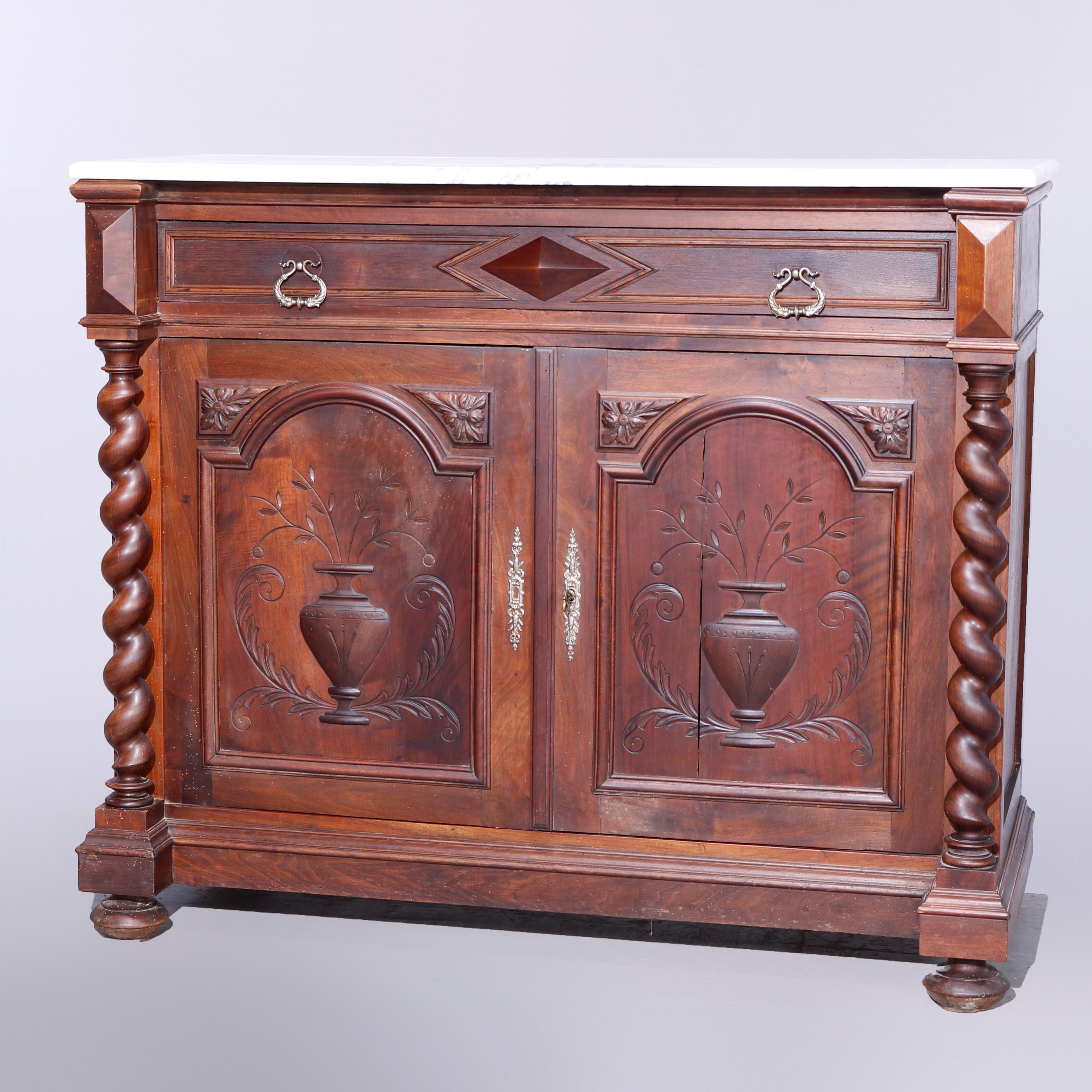 An antique English Elizabethan sideboard offers beveled marble top over case with frieze drawer having central pyramidal element surmounting cabinet with double doors having carved floral urn decoration opening to a shelved interior and flanked by