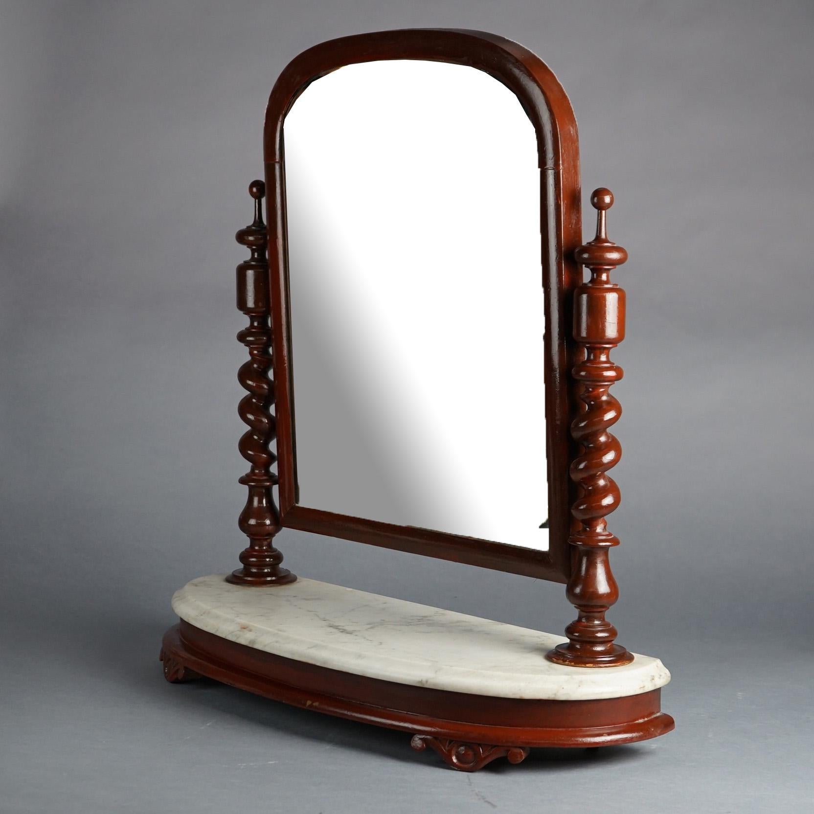 Antique English Elizabethan shaving mirror offers mahogany construction with arched mirror having flanking rope twist supports over marble top base, 19th century

Measures- 27.75''H x 26.75''W x 9.25''D