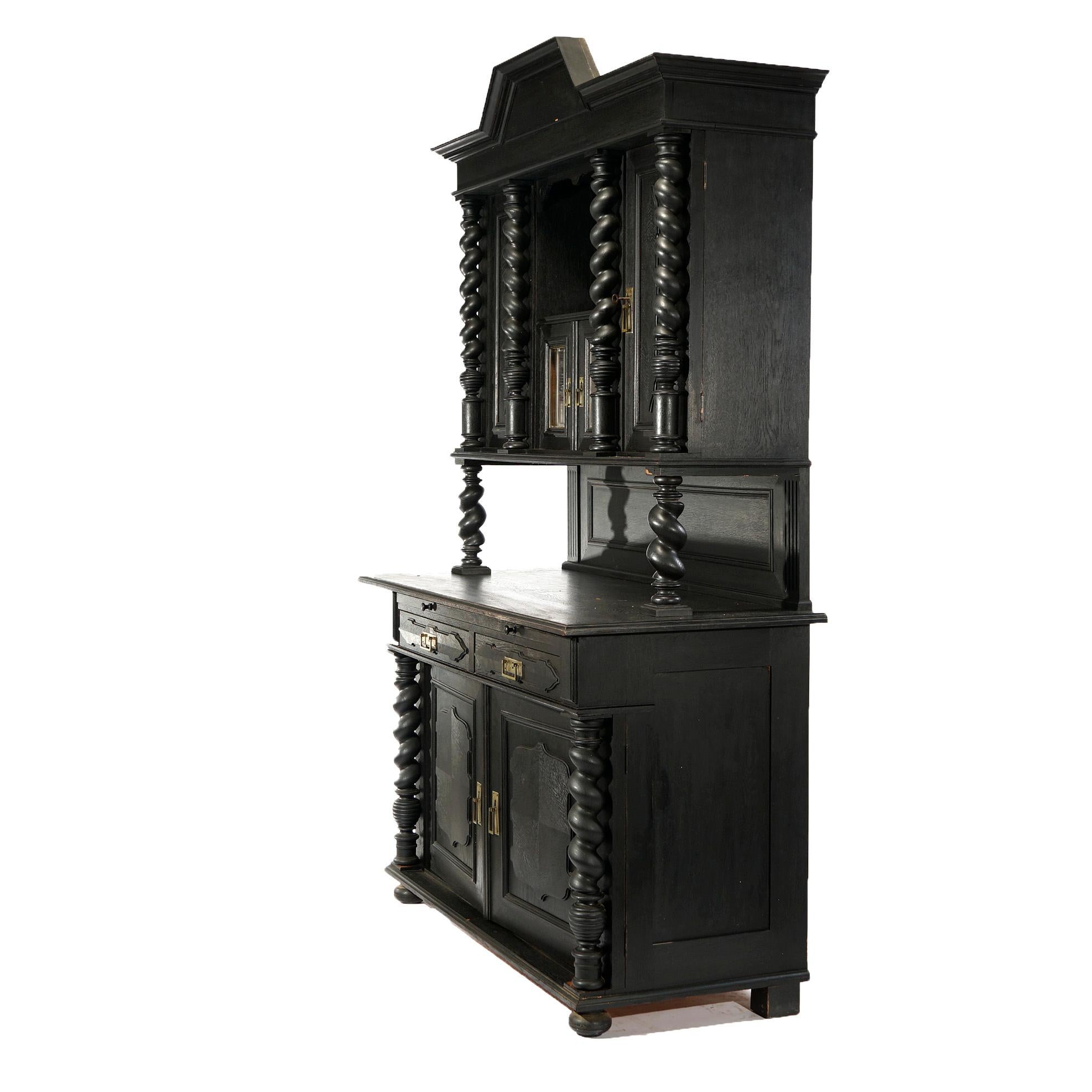 An antique English Elizabethan style hunt cupboard offers oak construction with upper having shaped crest over open shelf and double glass door cabinet with flanking tall cabinets having raised panel doors and rope twist supports over lower with two