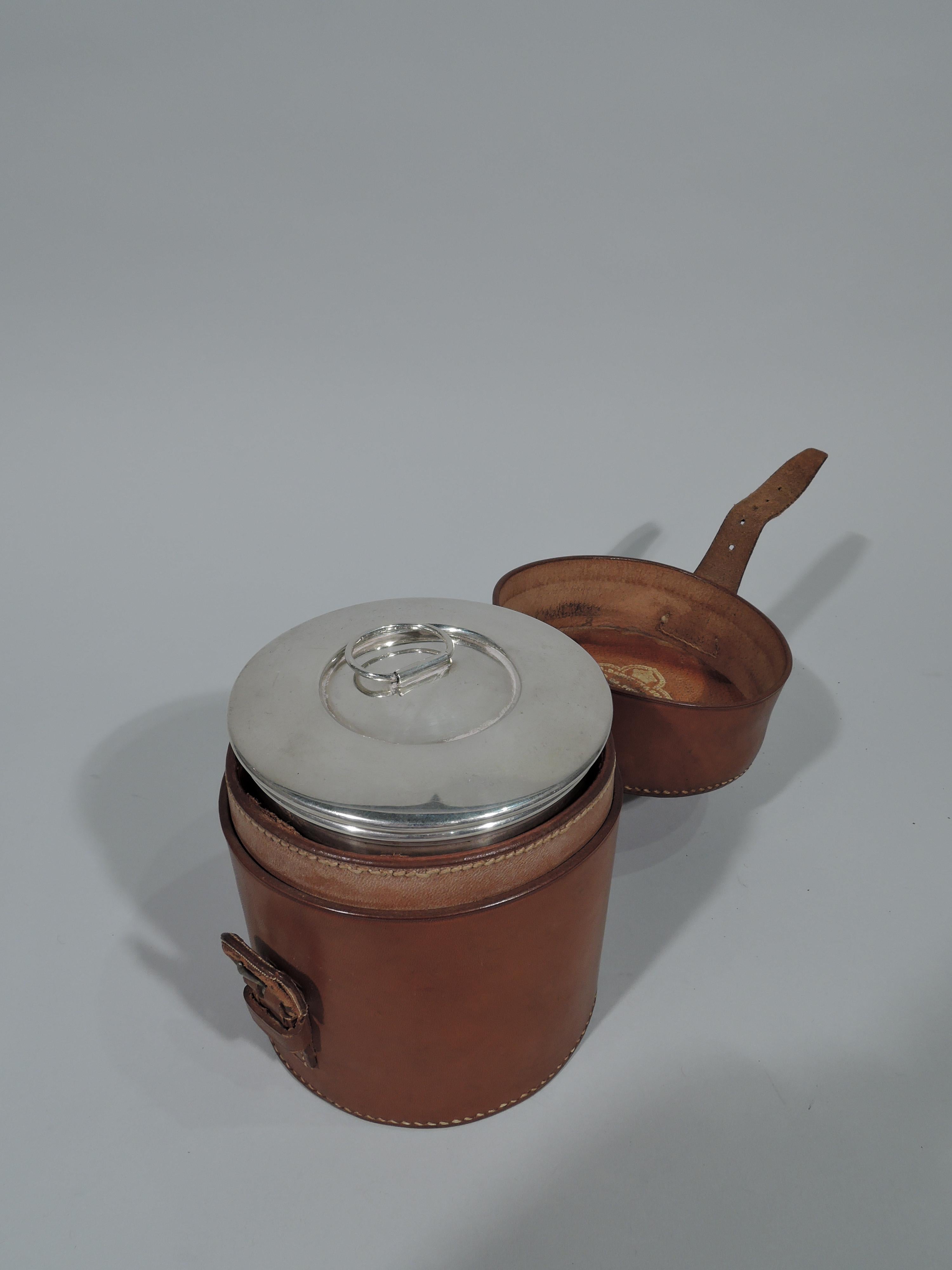 Edwardian sterling silver portable water pot. Made by A. Barrett & Sons in London in 1906. Drum form with small spout and carved and threaded handle. Snug-fitting cover with loose ring finial. Burner, fuel canister, and Stand. Engraved armorial was