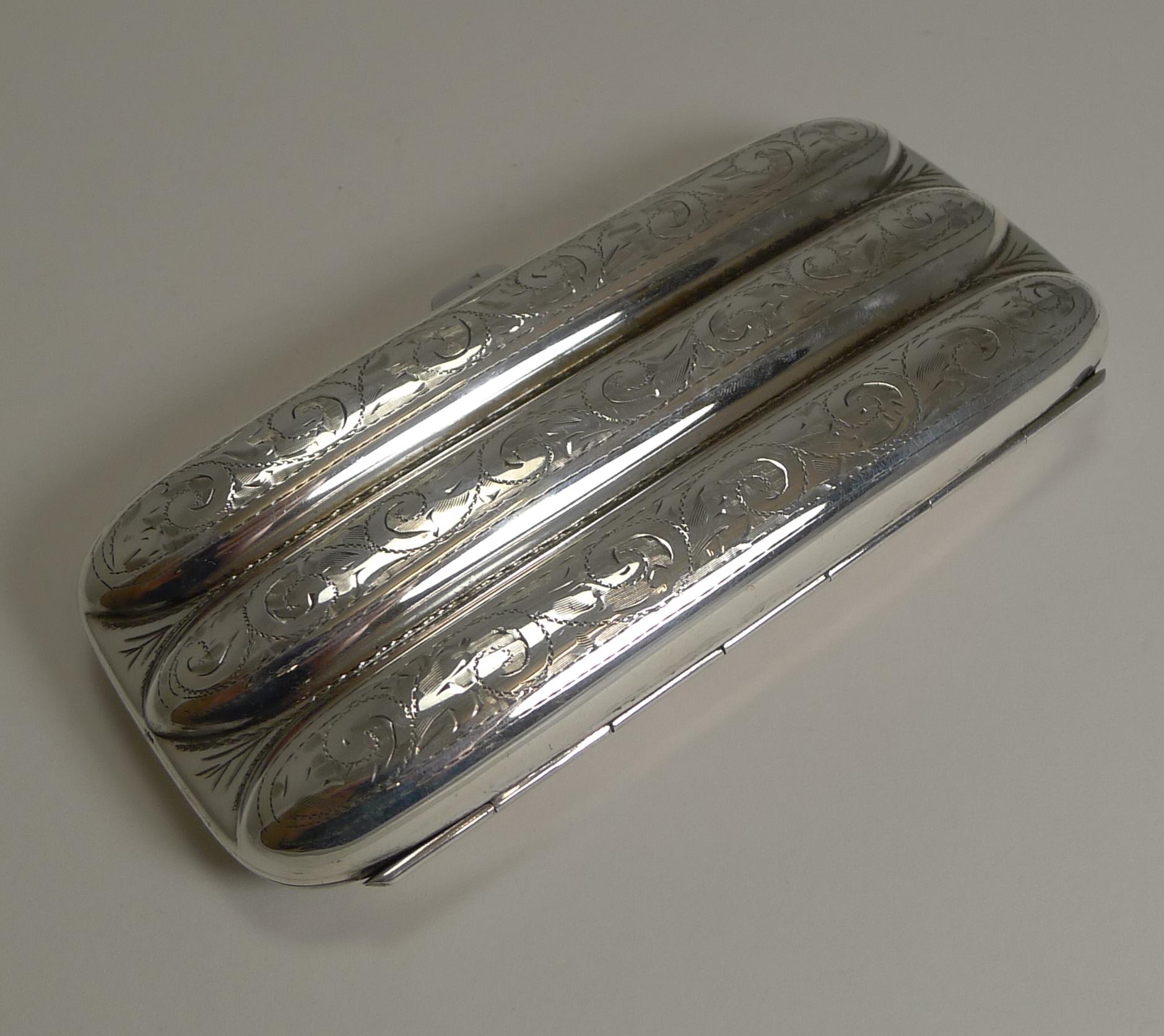 A very smart and lovely quality sterling silver cigar case, with a three-finger configuration beautifully engraved with the front of the central finger with a diagonal vacant cartouche.

The hinged case is opened with a press catch to the side and