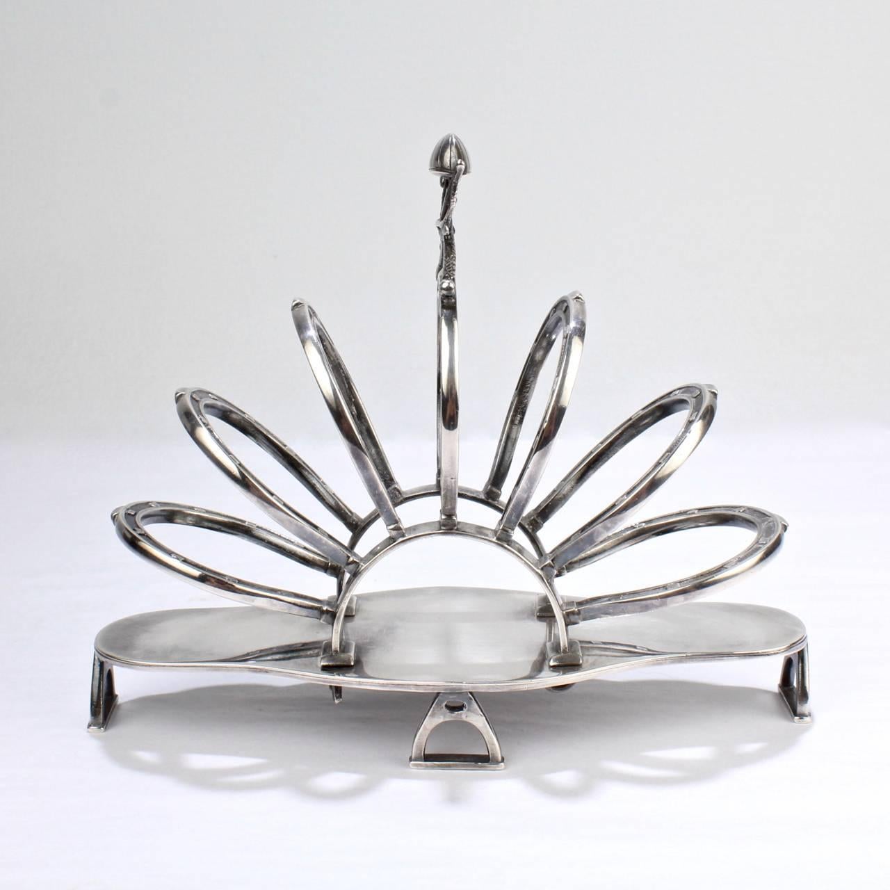 A very fine late Victorian figural English silver-plated toast rack.

The design of this striking toast rack has an Equestrian theme from top to bottom.
'Stirrup' feet support a tray with 'horseshoe' dividers, and the top bears a 'riding crop and